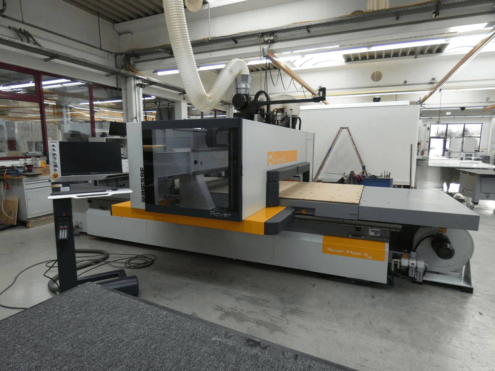 Widok z przodu centrum obróbki drewna BIESSE ROVER PLAST A FT 1224 z systemem CNC, na którym widoczny jest monitor i panel sterowania.
