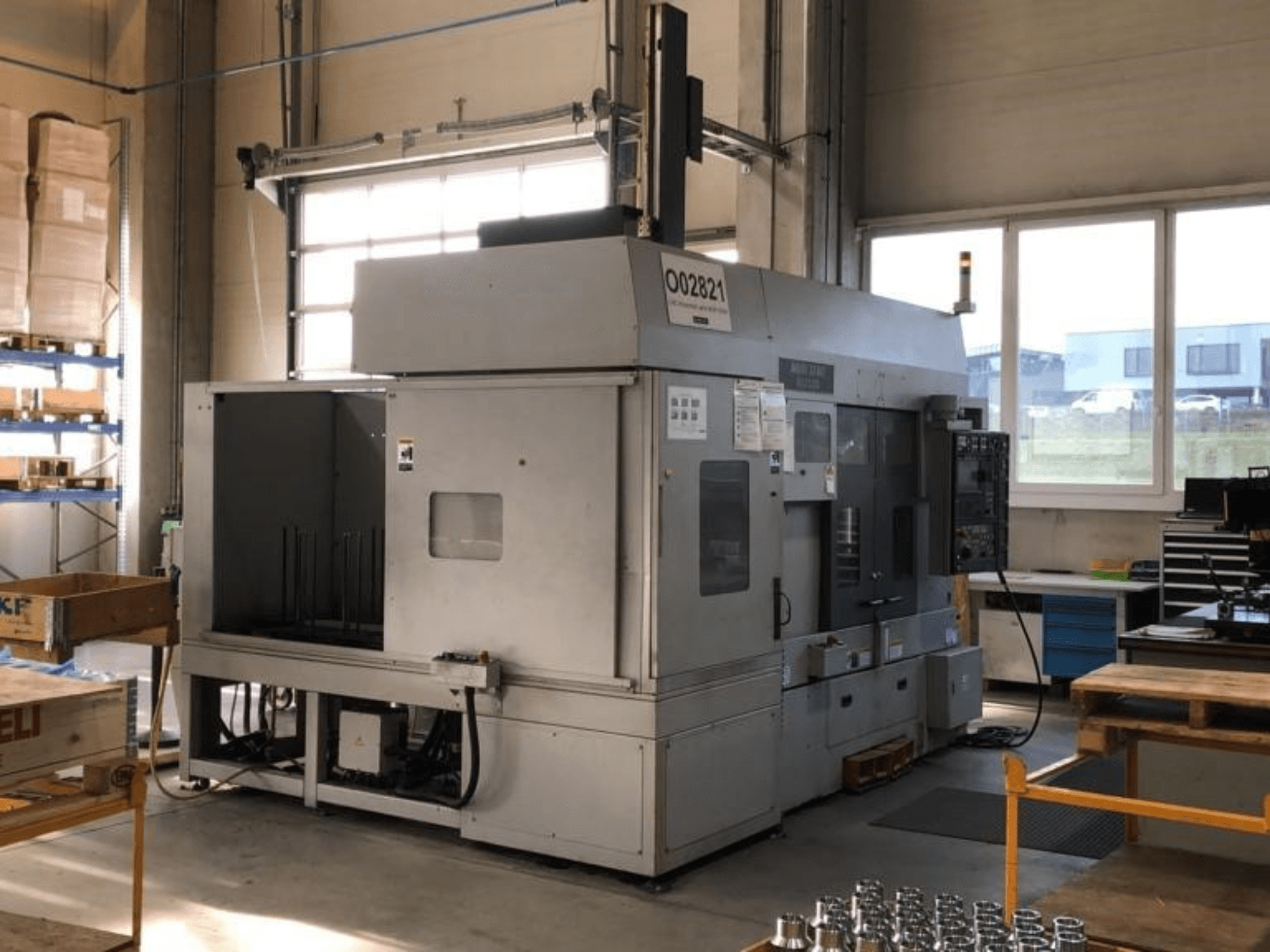 Tokarka wielowrzecionowa MORI SEIKI RL2500 w warsztacie, widok z przodu i obszar produkcyjny z narzędziami.