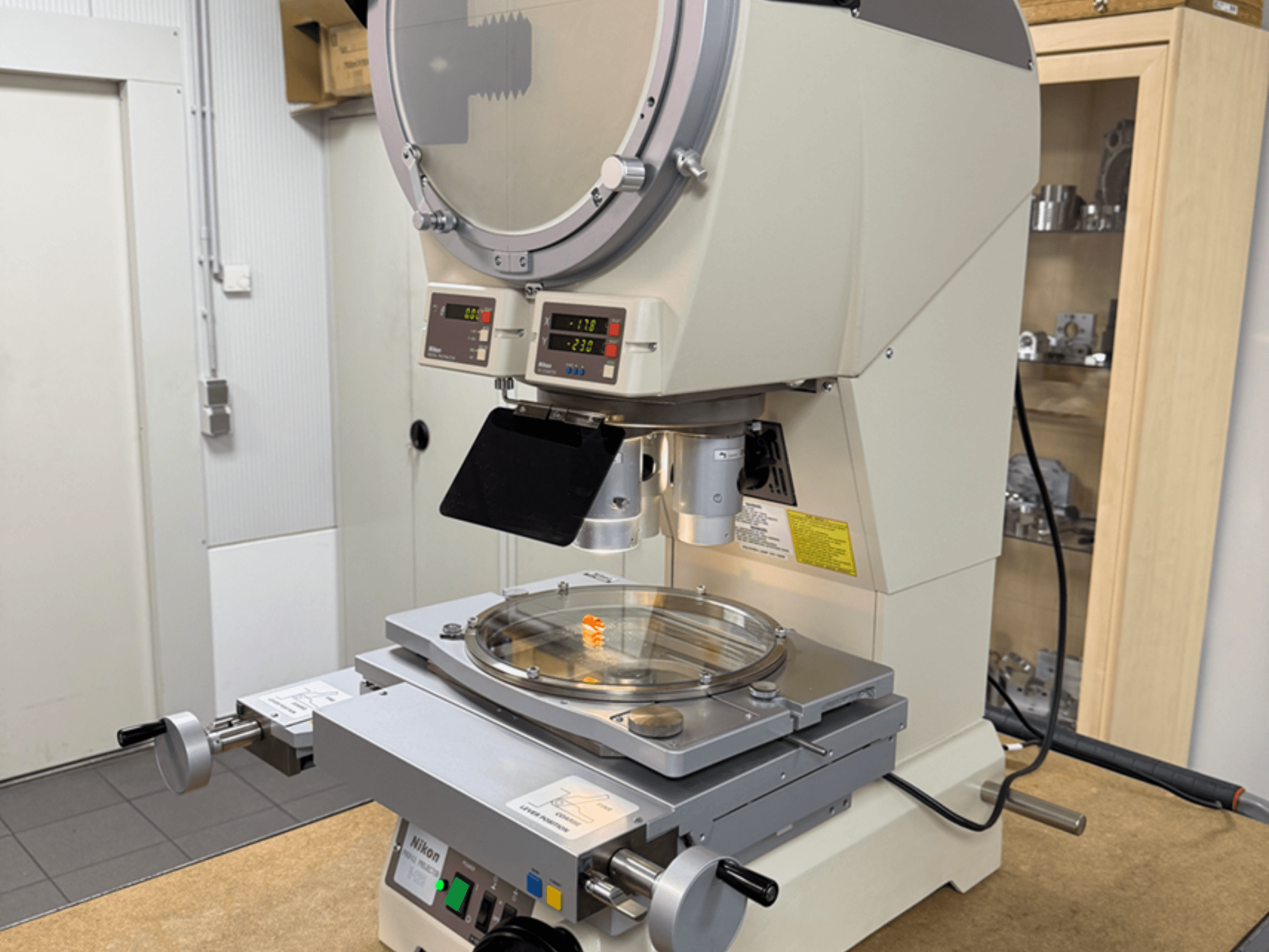 Model mikroskopu Nikon z widokiem z przodu, wyposażony w cyfrowe wyświetlacze, regulowany stolik i okrągłą szklaną płytkę.