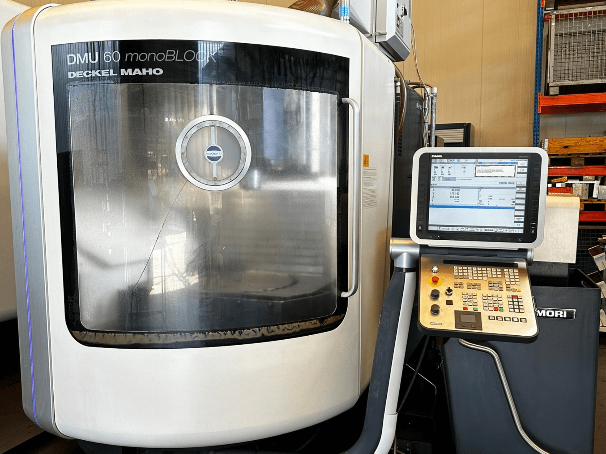 Pionowe centrum obróbcze DMG MORI DMU 60 monoBLOCK, widok z przodu, z panelem sterowania z ekranem dotykowym i oknem odblaskowym.