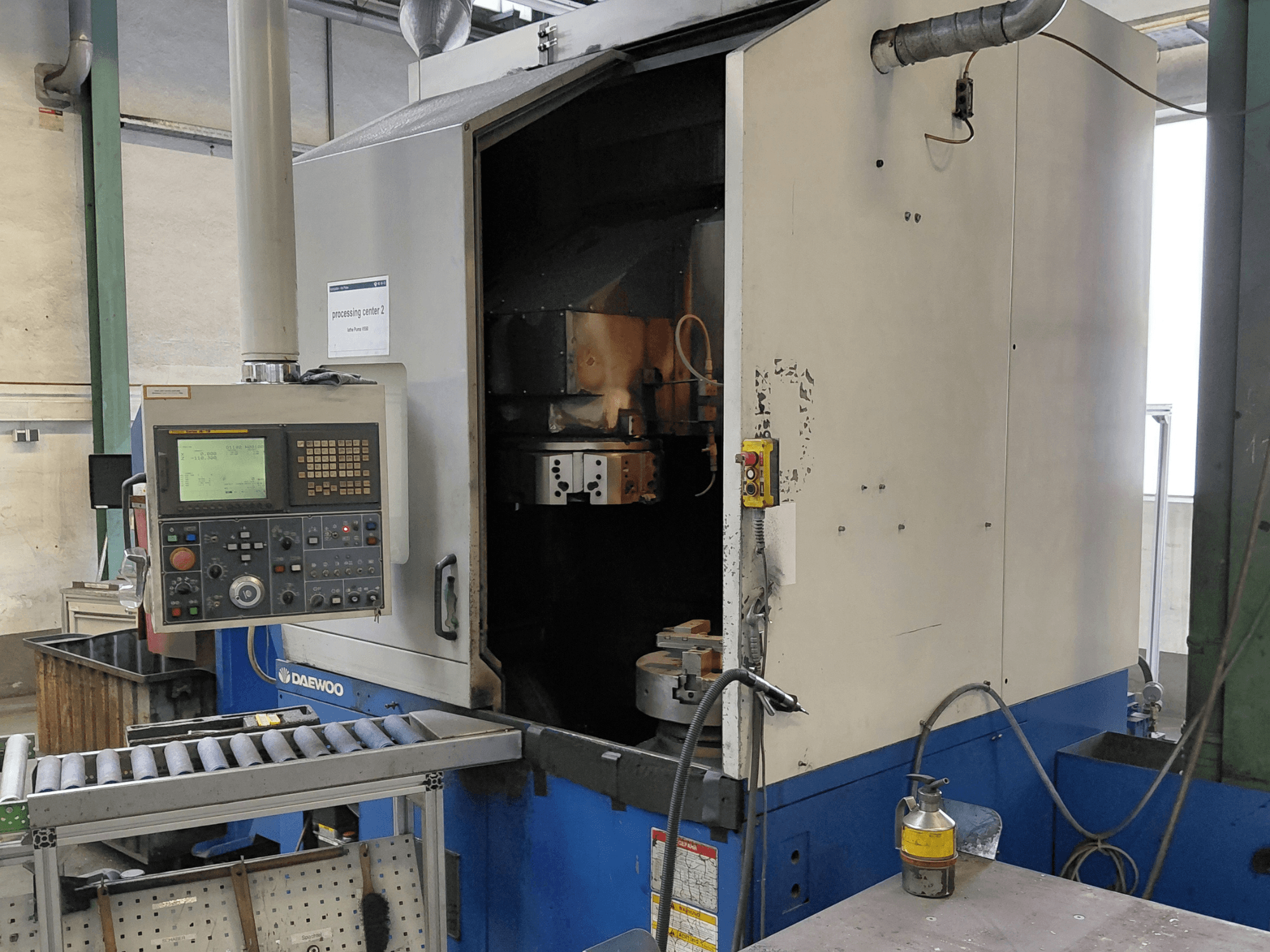 Tokarka pionowa Daewoo Puma V550, widok z przodu przedstawiający panel sterowania, wrzeciono i przyłącze chłodziwa.