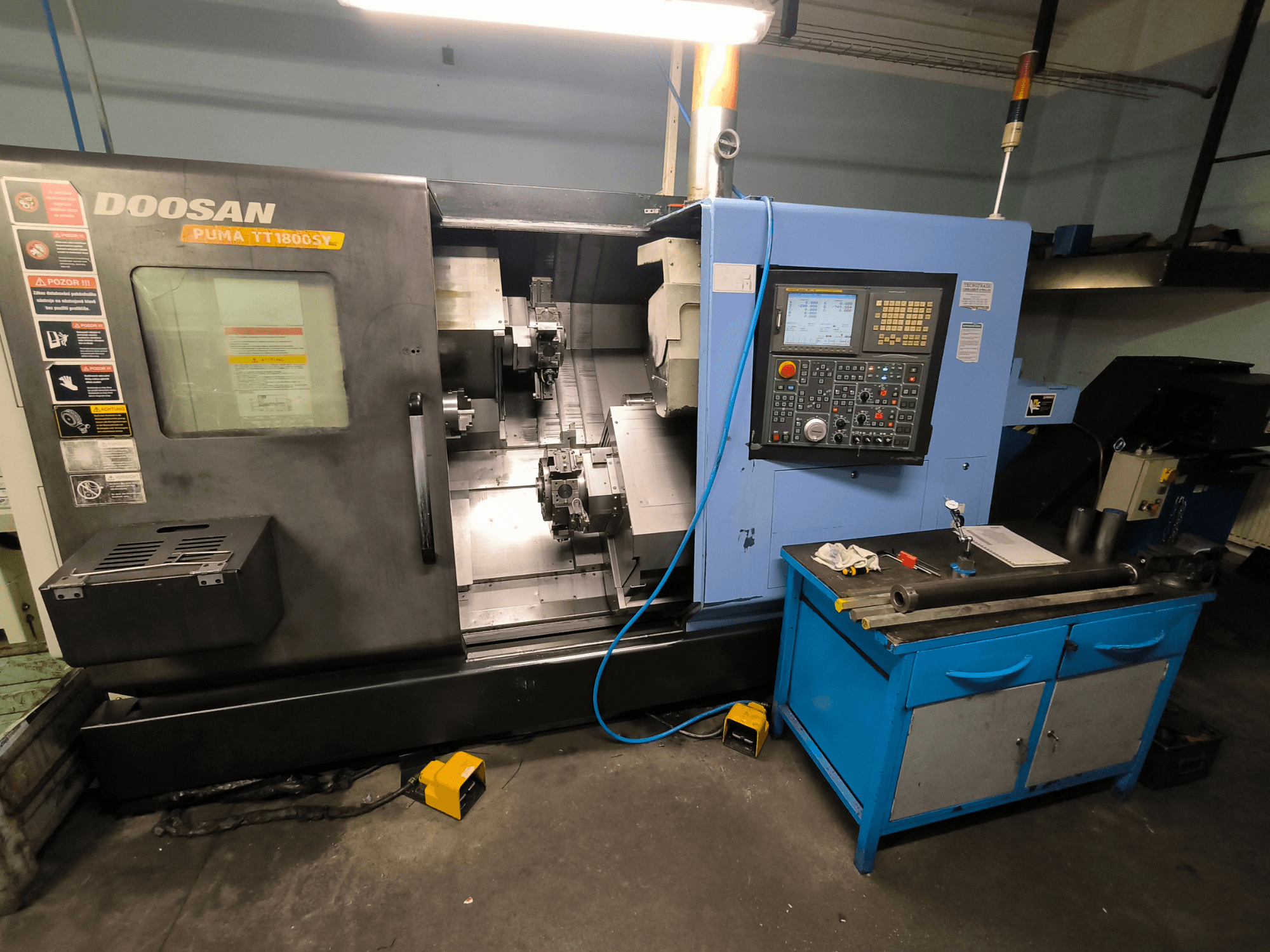 Tokarka CNC Doosan Puma TT1800SY, widok z przodu, pokazujący panel sterowania, obszar roboczy z narzędziami i komponenty maszyny.