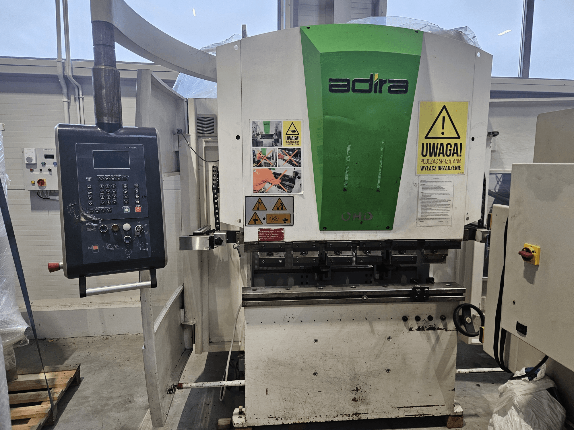 Maszyna Adira OHD widziana od przodu, z panelem sterowania, ostrzeżeniami bezpieczeństwa i przyciskami operacyjnymi.