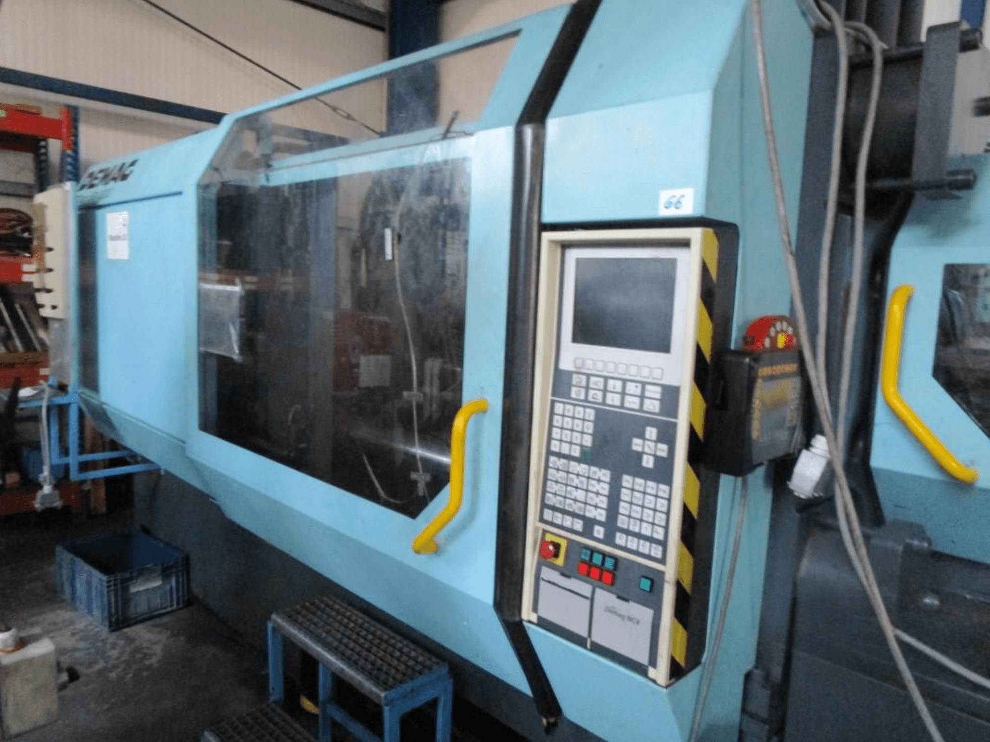 Hydrauliczna wtryskarka Demag Erdotech 500-3300, widok z przodu, z panelem sterowania i przezroczystą obudową bezpieczeństwa.