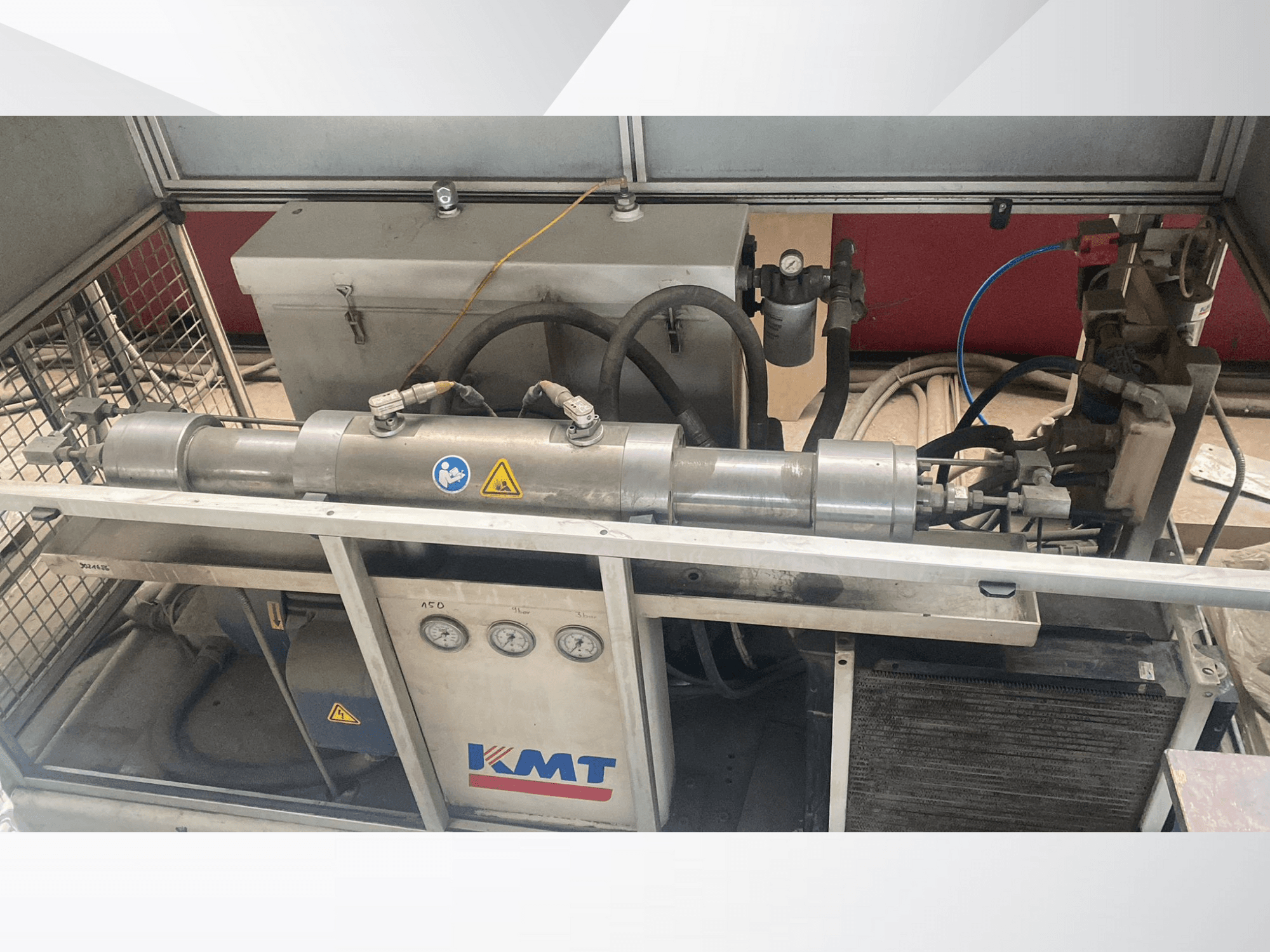 Maszyna hydrauliczna KMT w widoku z przodu, wyposażona w manometry, węże i metalową obudowę, idealna do zastosowań przemysłowych.