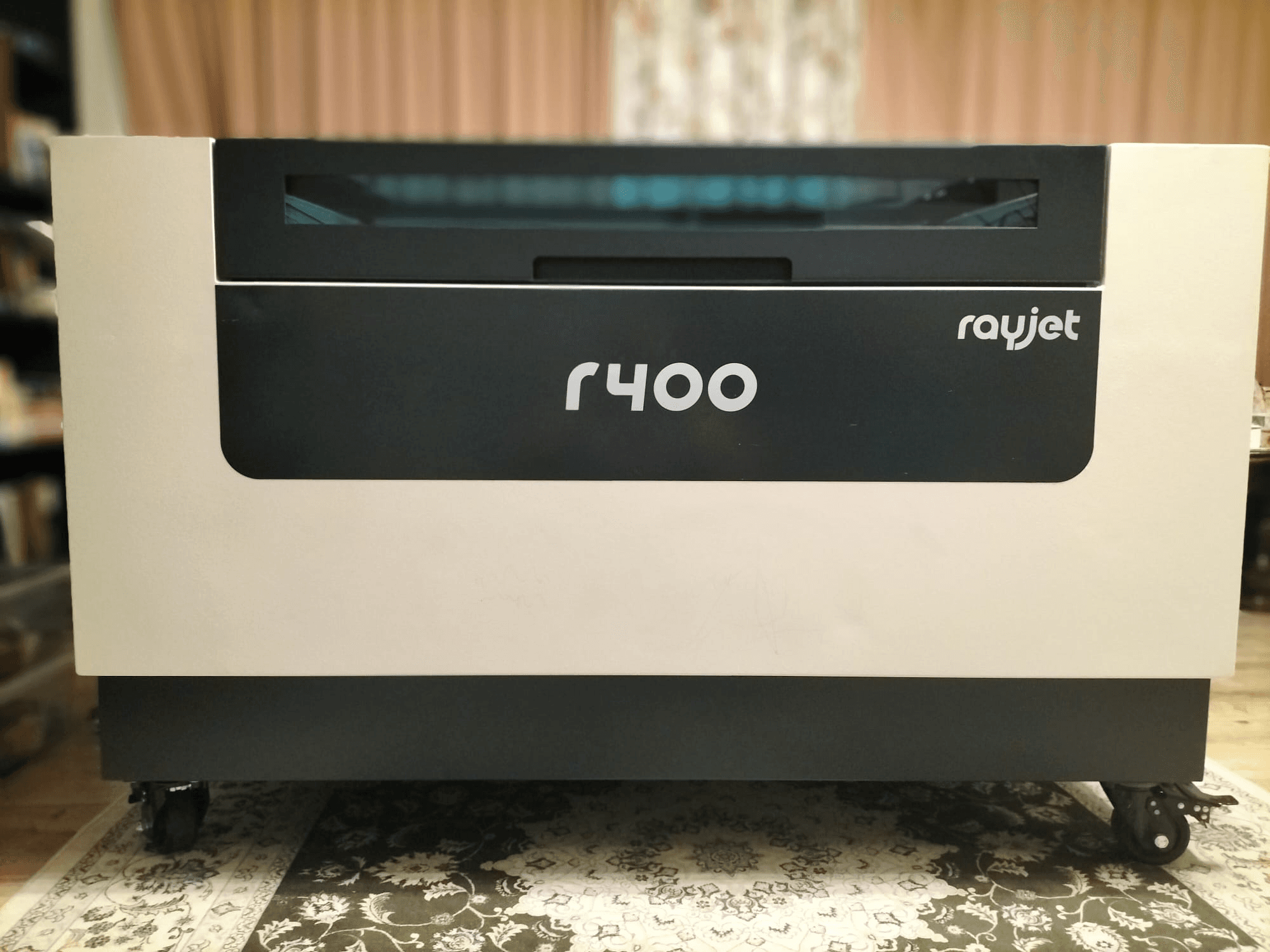 Widok z przodu grawerki laserowej Trotec Rayjet R400, prezentujący jej elegancki wygląd i wyraźny znak firmowy.