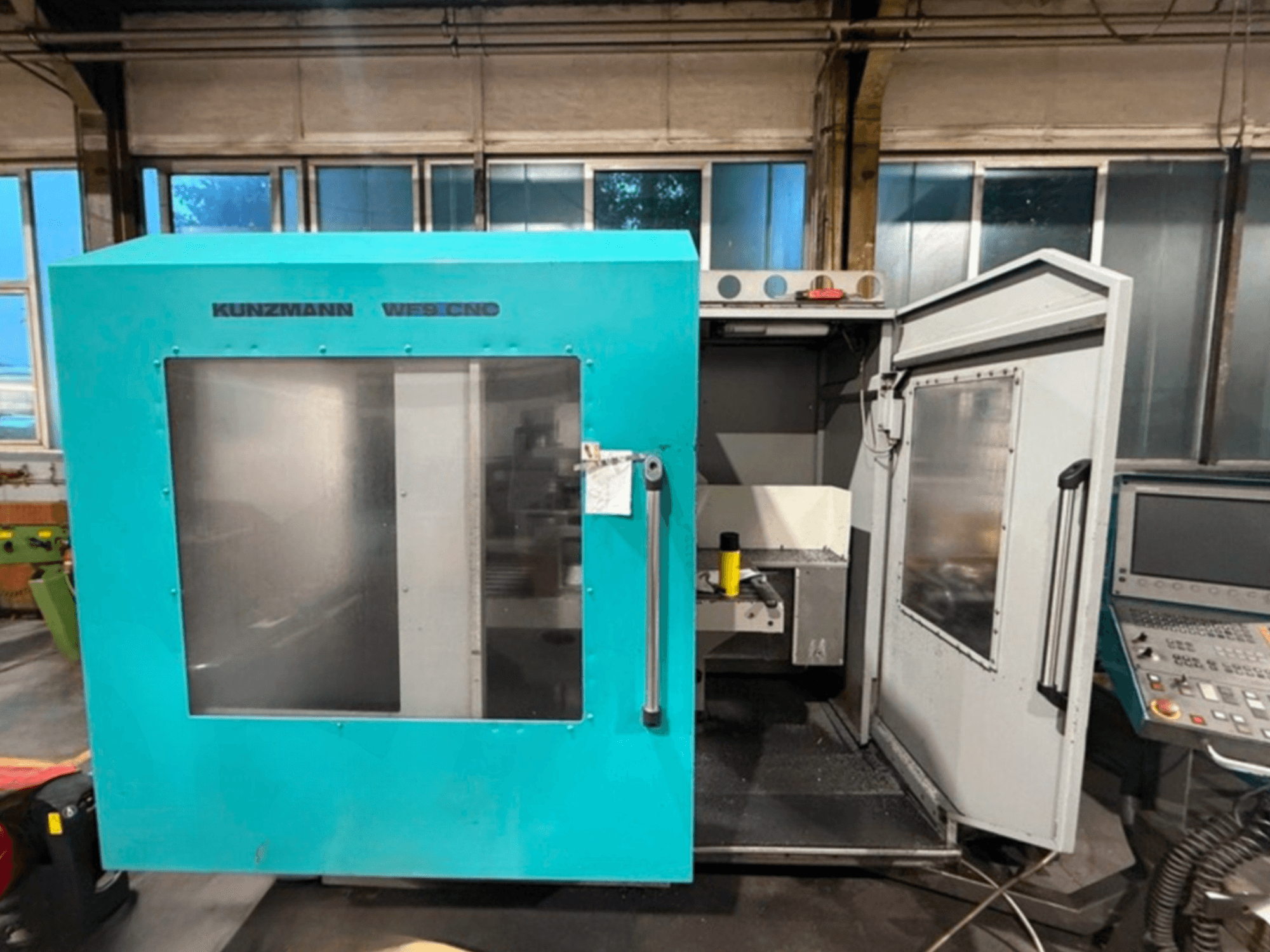 Pionowe centrum obróbcze CNC KUNZMANN WF9, widok z przodu z otwartymi drzwiami, prezentujący wnętrze i panel sterowania.