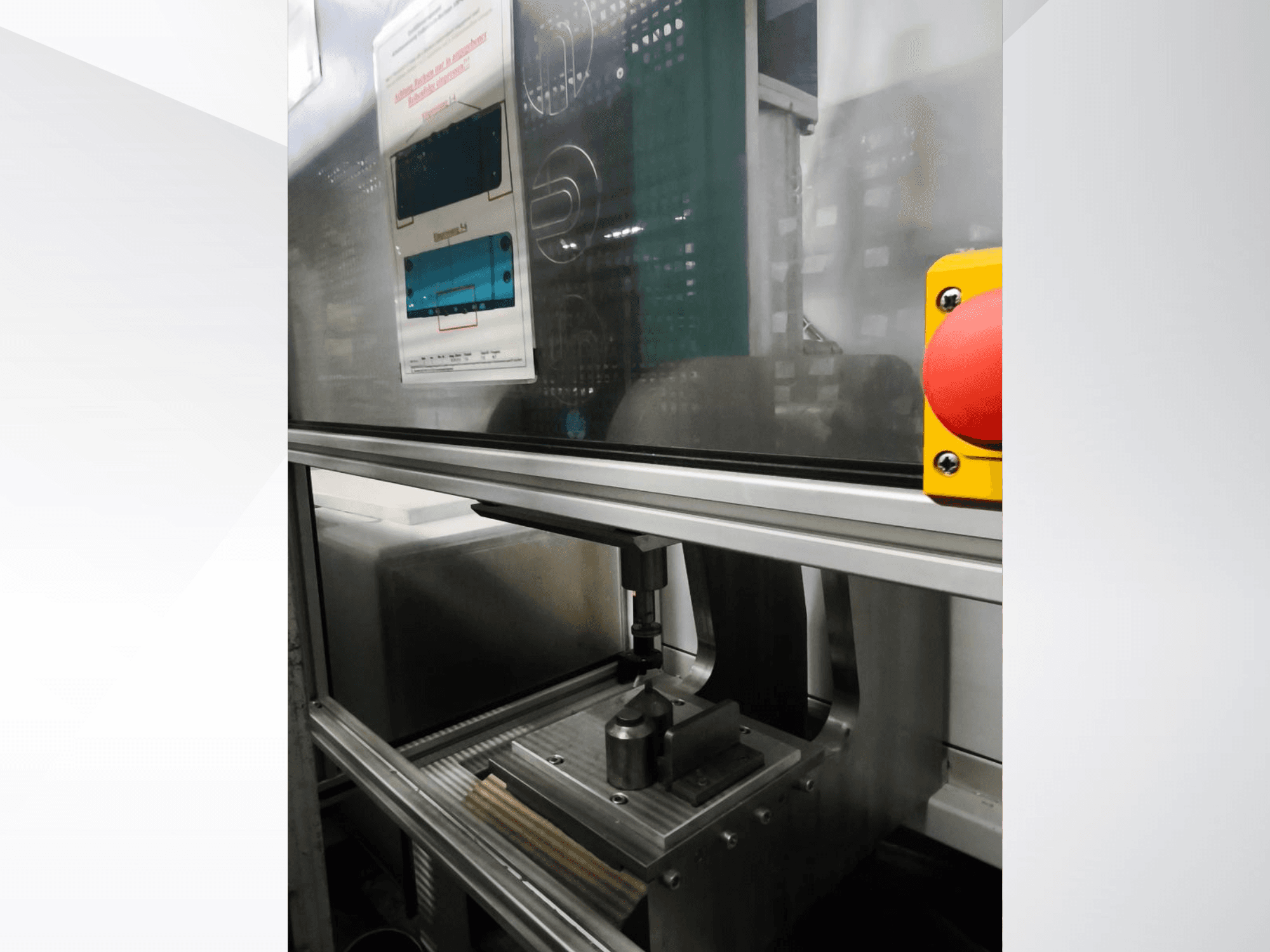 Widok z przodu obrabiarki EMS Automation Buchsenpresse, przedstawiający mechanizm dociskowy i przycisk bezpieczeństwa.