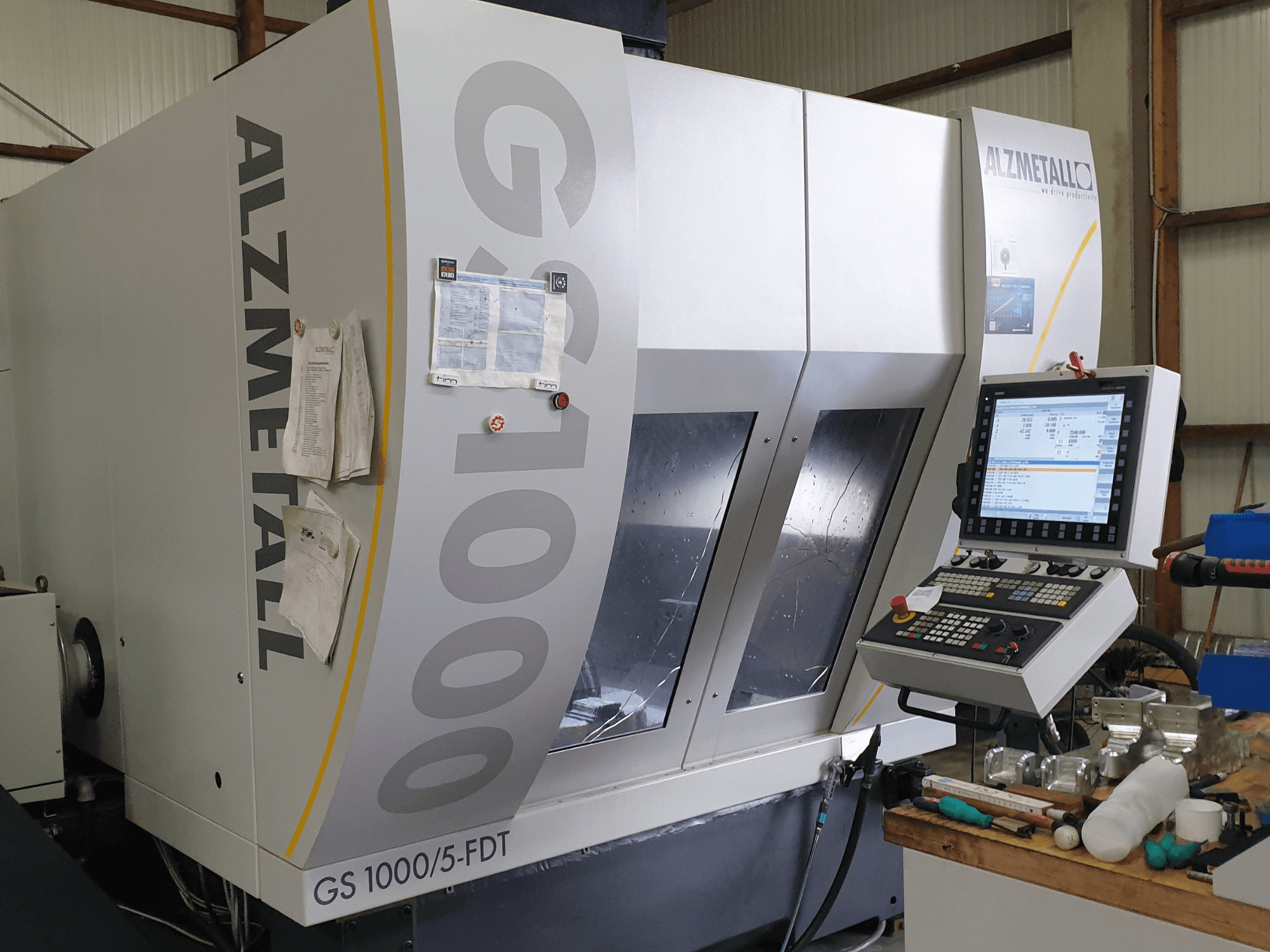 Pionowe centrum obróbcze Alzmetall GS 1000/5-FDT widziane od przodu, z widocznym panelem sterowania i obszarem roboczym.