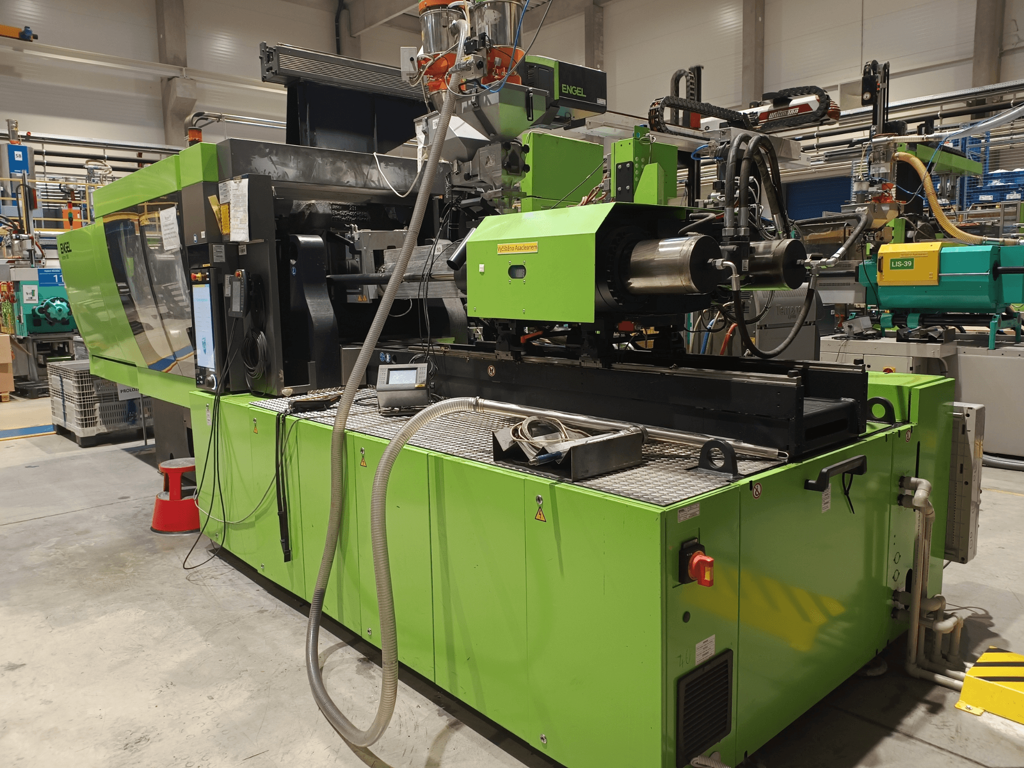 Wtryskarka Engel, widok z boku, zielona obudowa, z widocznym panelem dotykowym i elementami hydraulicznymi.