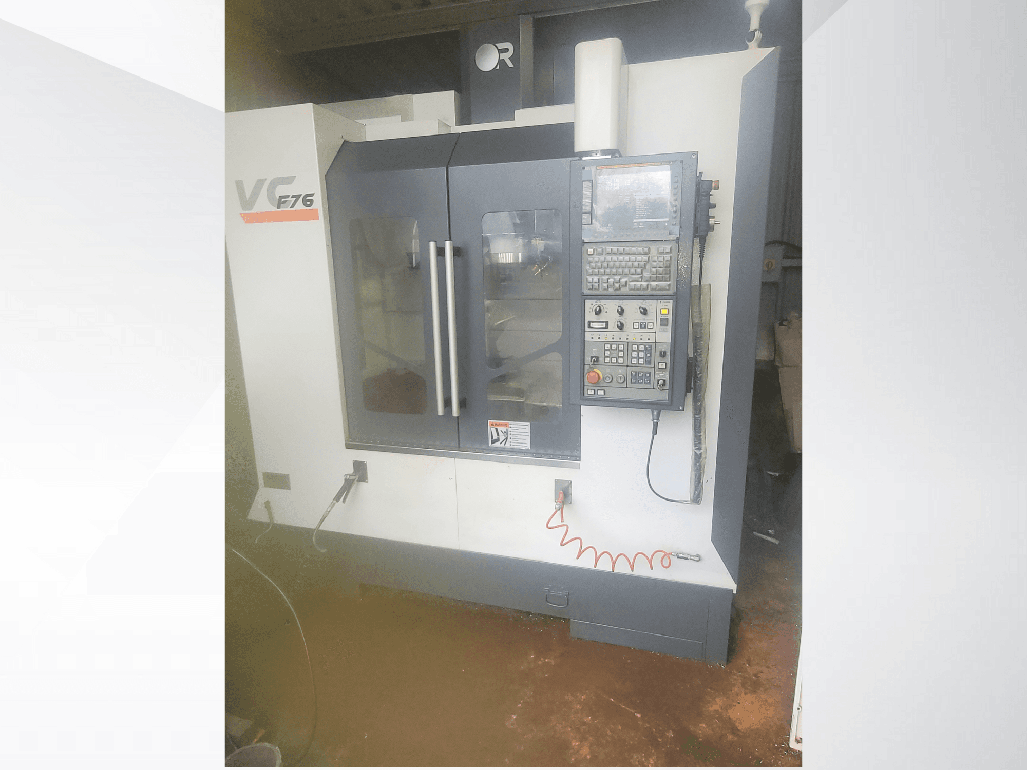 Pionowe centrum obróbcze, marka VC, model F76; widok z przodu przedstawiający panel sterowania i szklane drzwi.