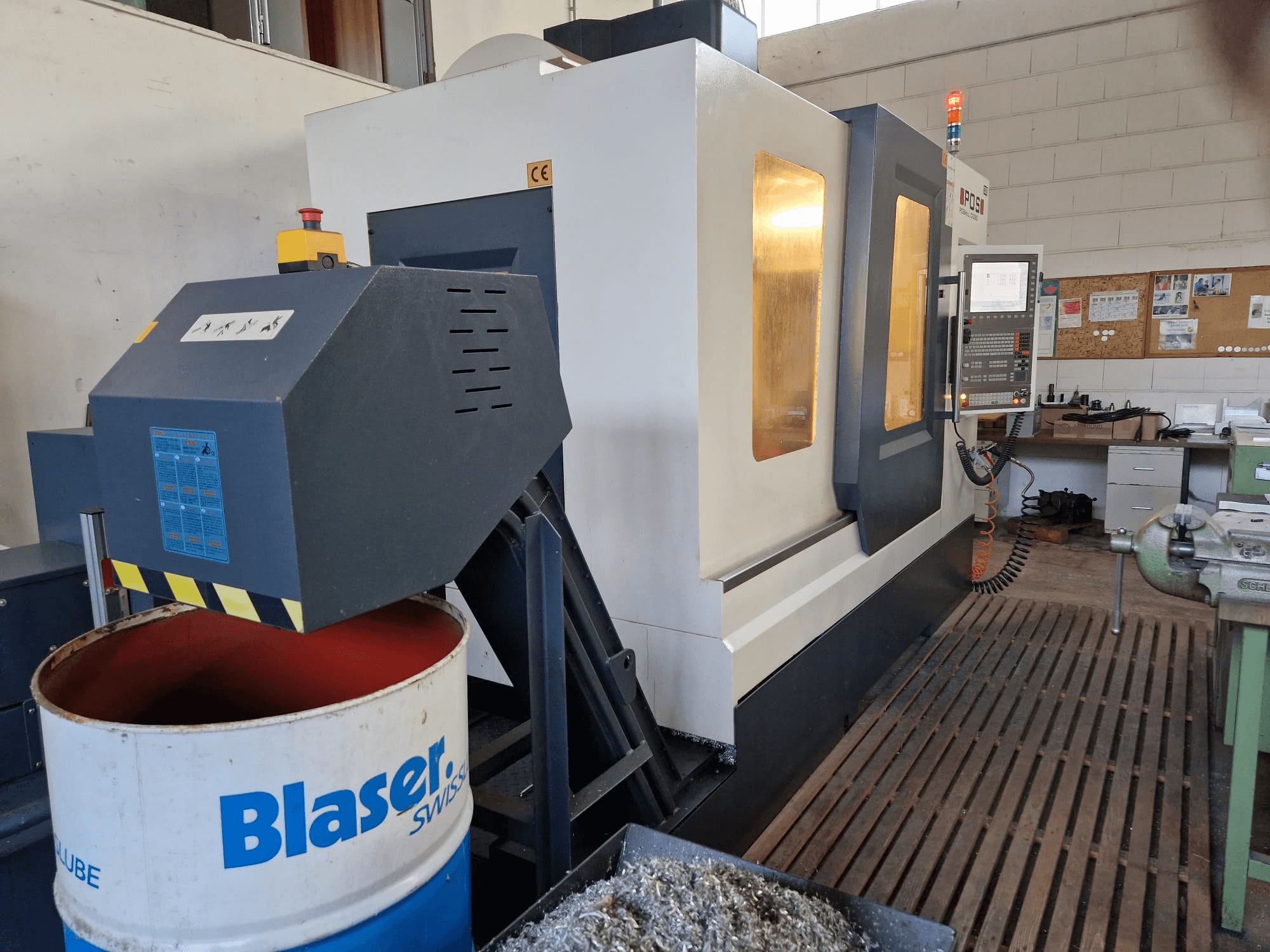 Widok z przodu pionowego centrum obróbczego POSmill C 1050, z widocznym układem chłodzenia nad bębnem Blaser i panelem sterowania.