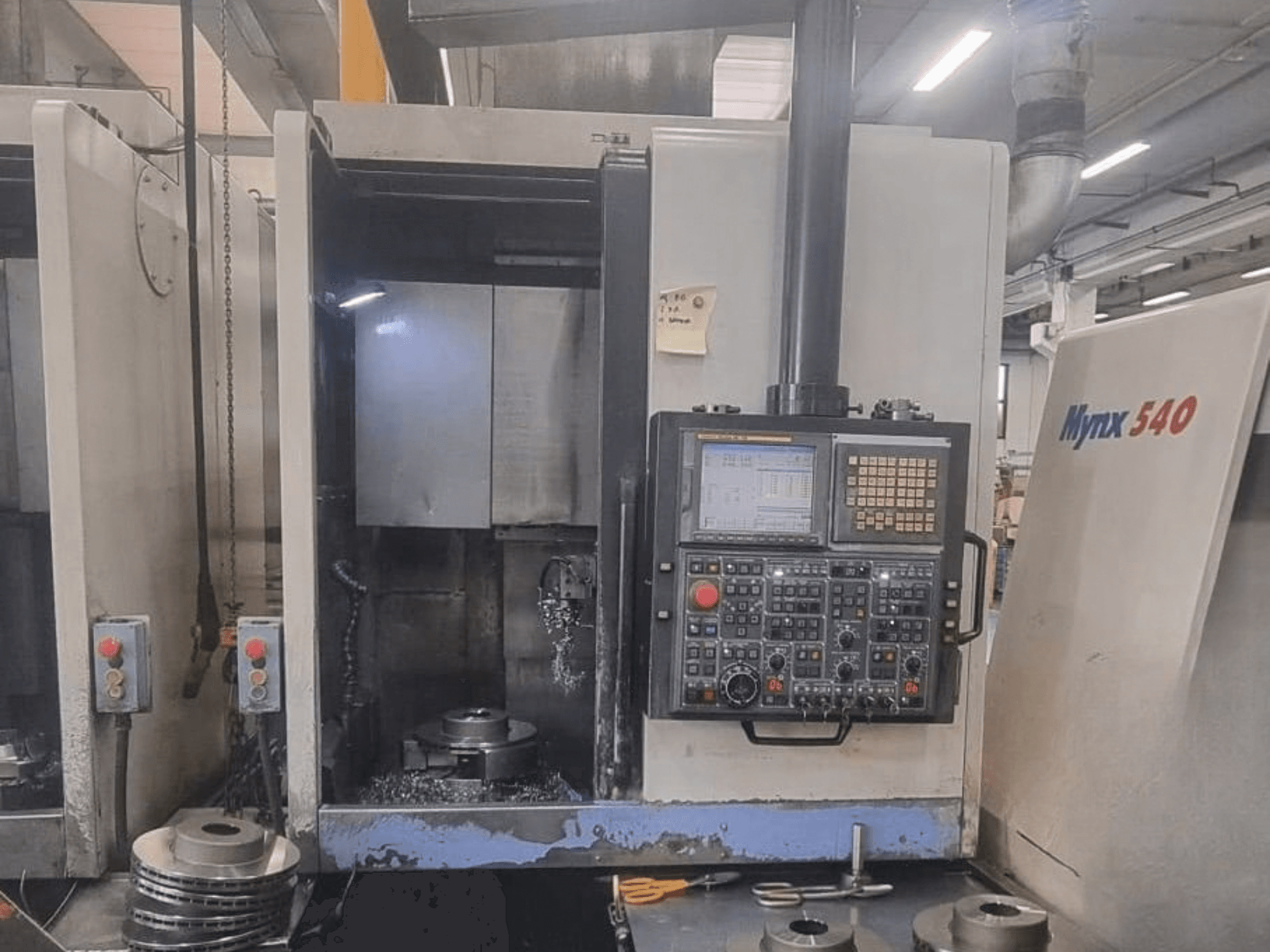 Widok z przodu pionowej tokarki DOOSAN PUMA V400-2SP, przedstawiający panel sterowania oraz ustawienie obrabianego elementu wewnątrz maszyny.