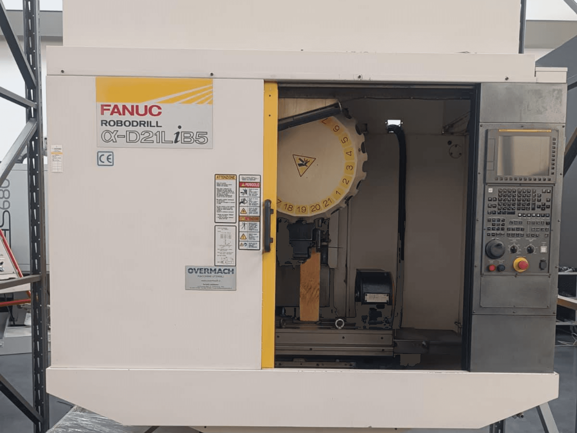 FANUC Robodrill α-D21LiB5, widok z przodu; maszyna CNC z widocznym uchwytem narzędziowym, panelem sterowania i ostrzeżeniami dotyczącymi bezpieczeństwa.
