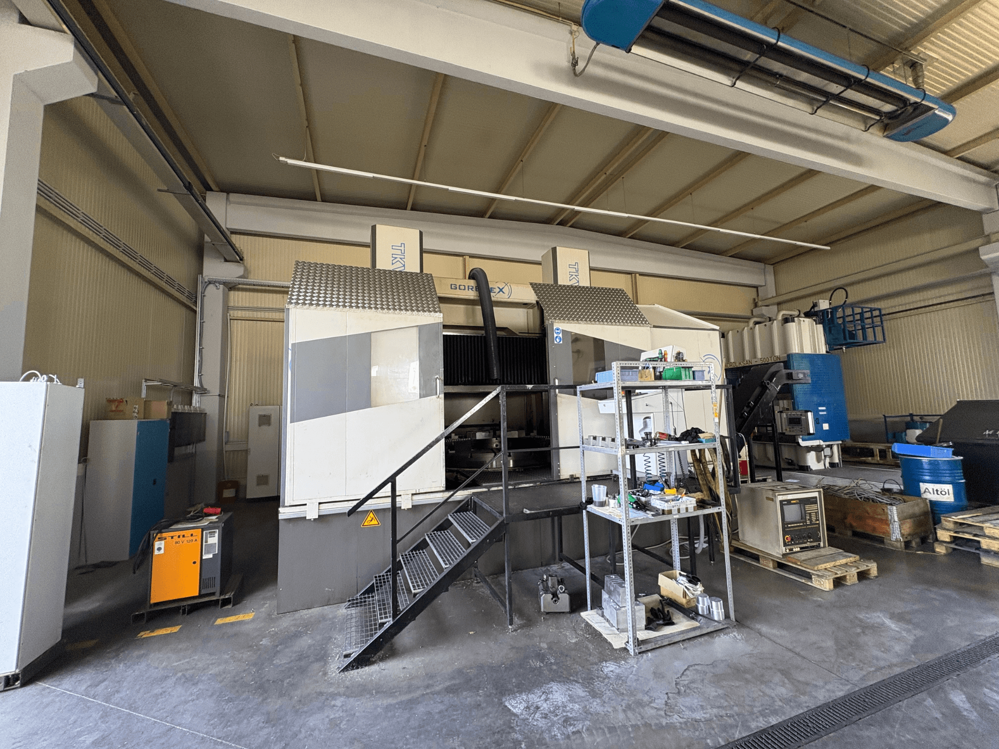 Zestaw do obróbki przemysłowej z maszyną GORAT X, widok z boku; zawiera narzędzia, panel sterowania i sprzęt na półkach.