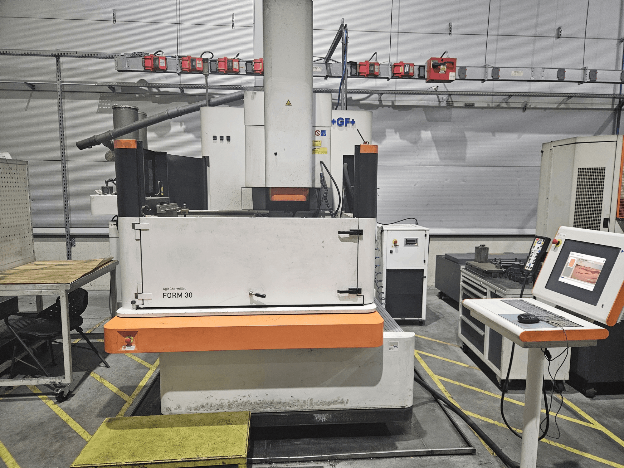 Maszyna ApeqChemicals FORM 30 w warsztacie, widok z przodu z panelem sterowania i stołem roboczym z boku.