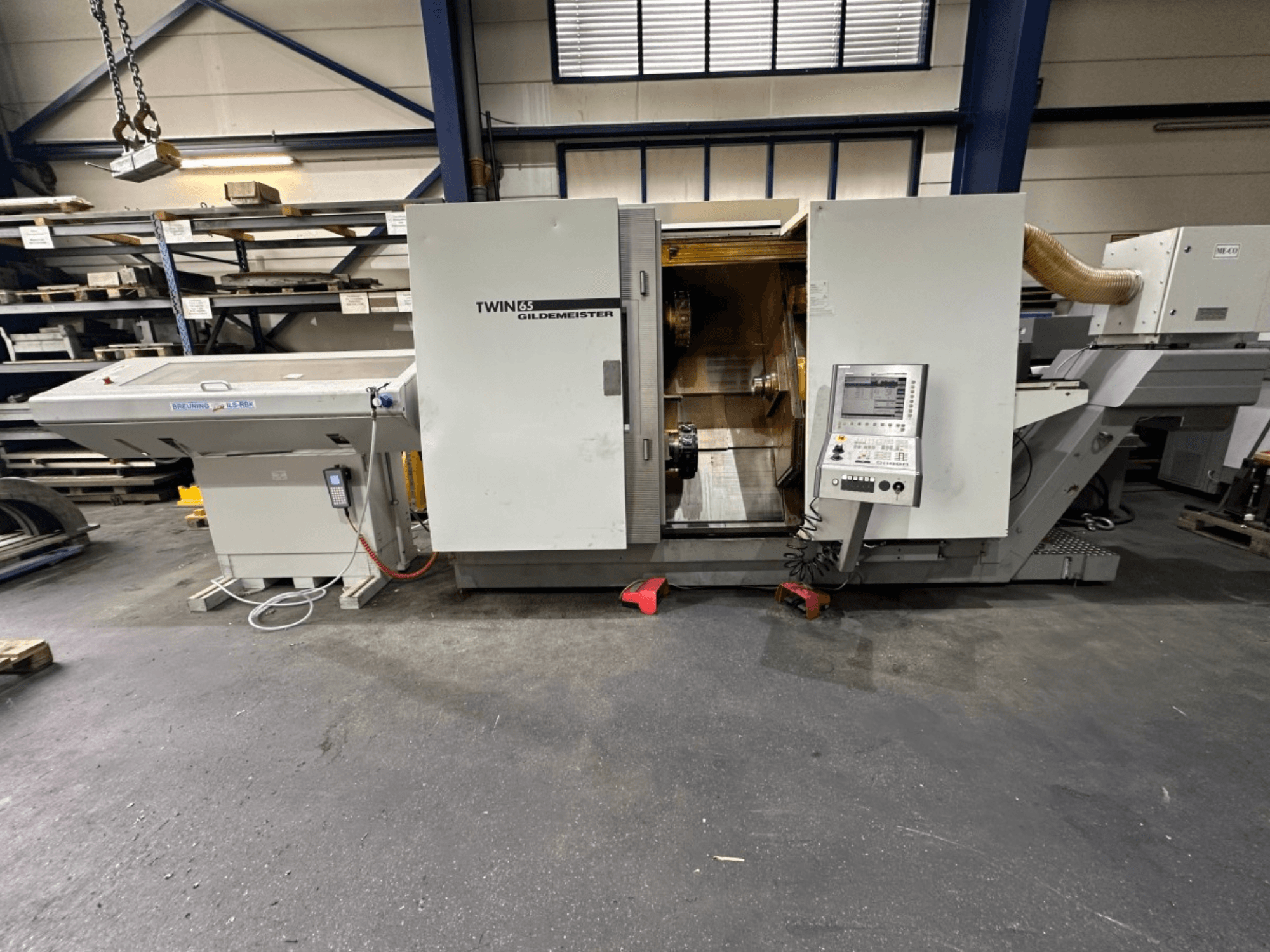 Tokarka pozioma Gildemeister TWIN 65, widok z przodu; posiada panel sterowania i widoczne wnętrze do obróbki części.