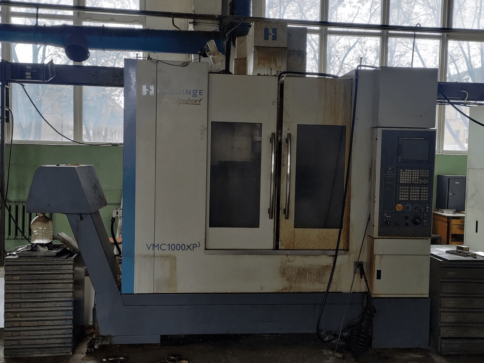 Pionowe centrum obróbcze Bridgeport VMC1000 XP3 – widok z przodu, na którym widać panel sterowania i niewielkie ślady zużycia.