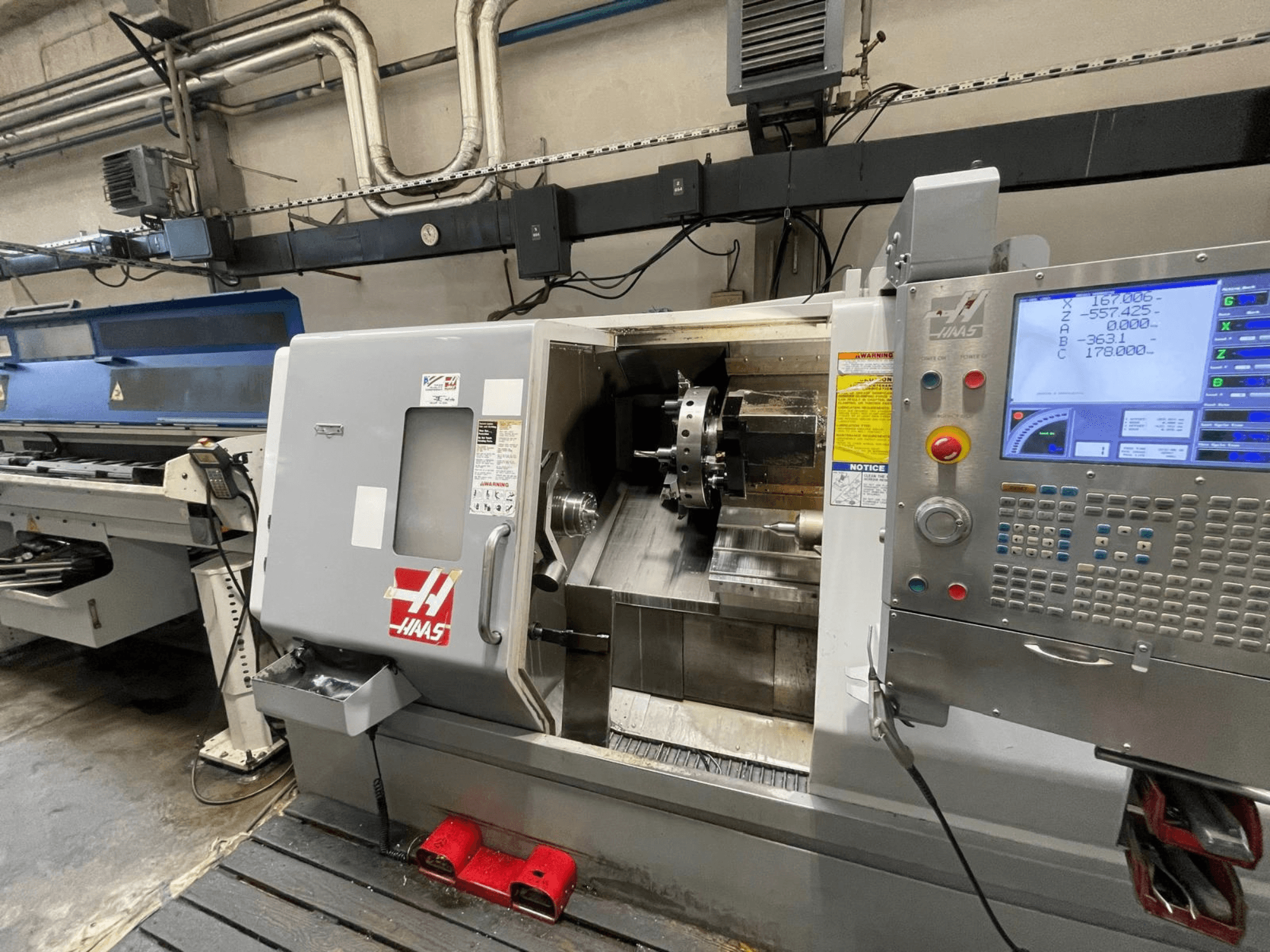 Tokarka pozioma Haas SL-30THE w warsztacie, wyposażona w cyfrowy panel sterowania i otwartą przestrzeń roboczą.