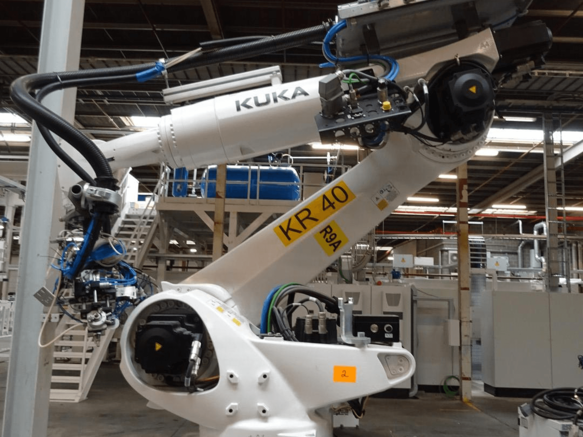 Ramię robota KUKA KR 120 R3100-2 w widoku z boku, prezentujące panel sterowania i komponenty mechaniczne, ustawione w środowisku przemysłowym.