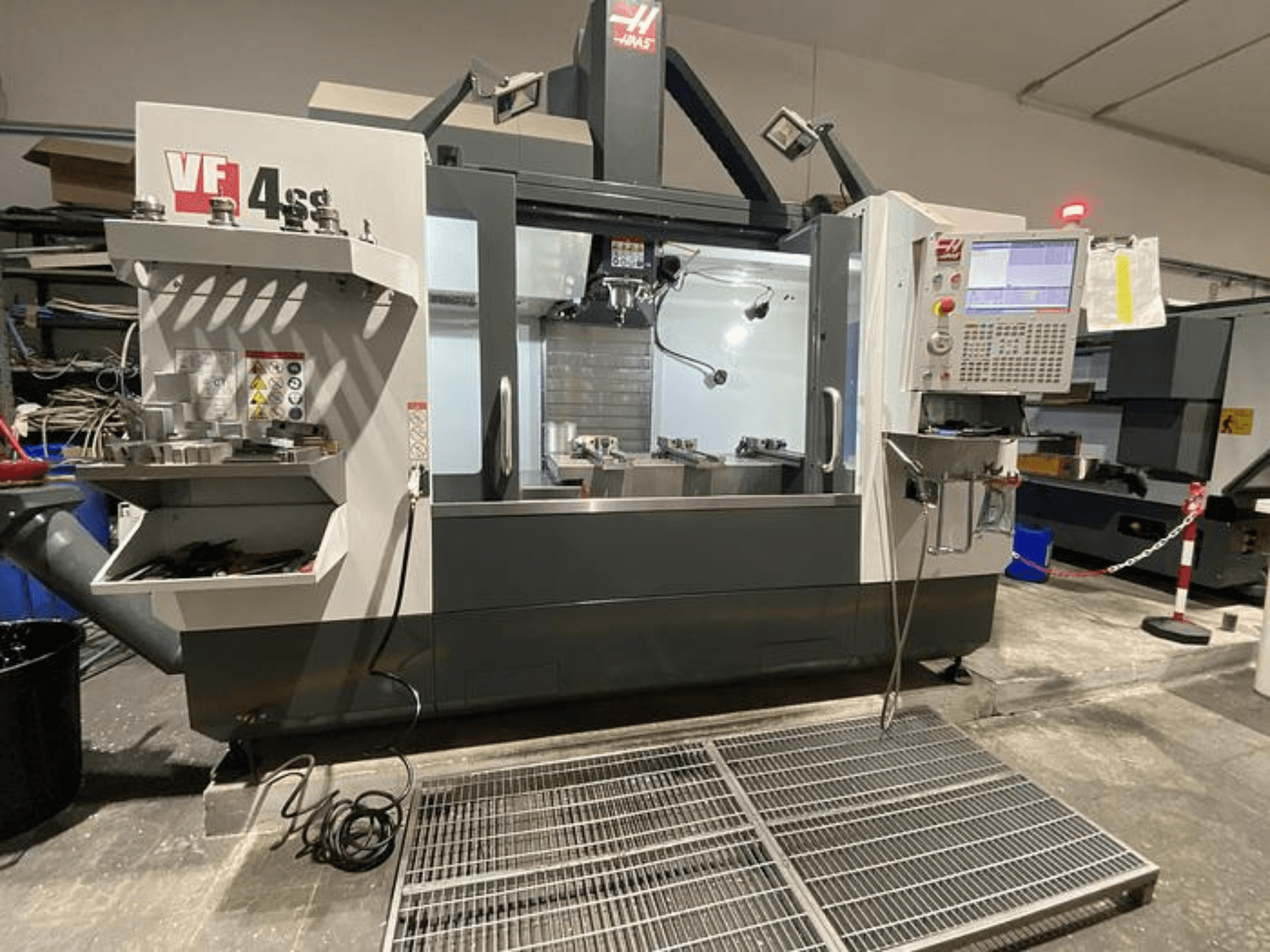 Frezarka CNC Haas VF-4SS, widok z przodu, z magazynem narzędzi, panelem sterowania i widocznym obszarem roboczym w warunkach warsztatowych.