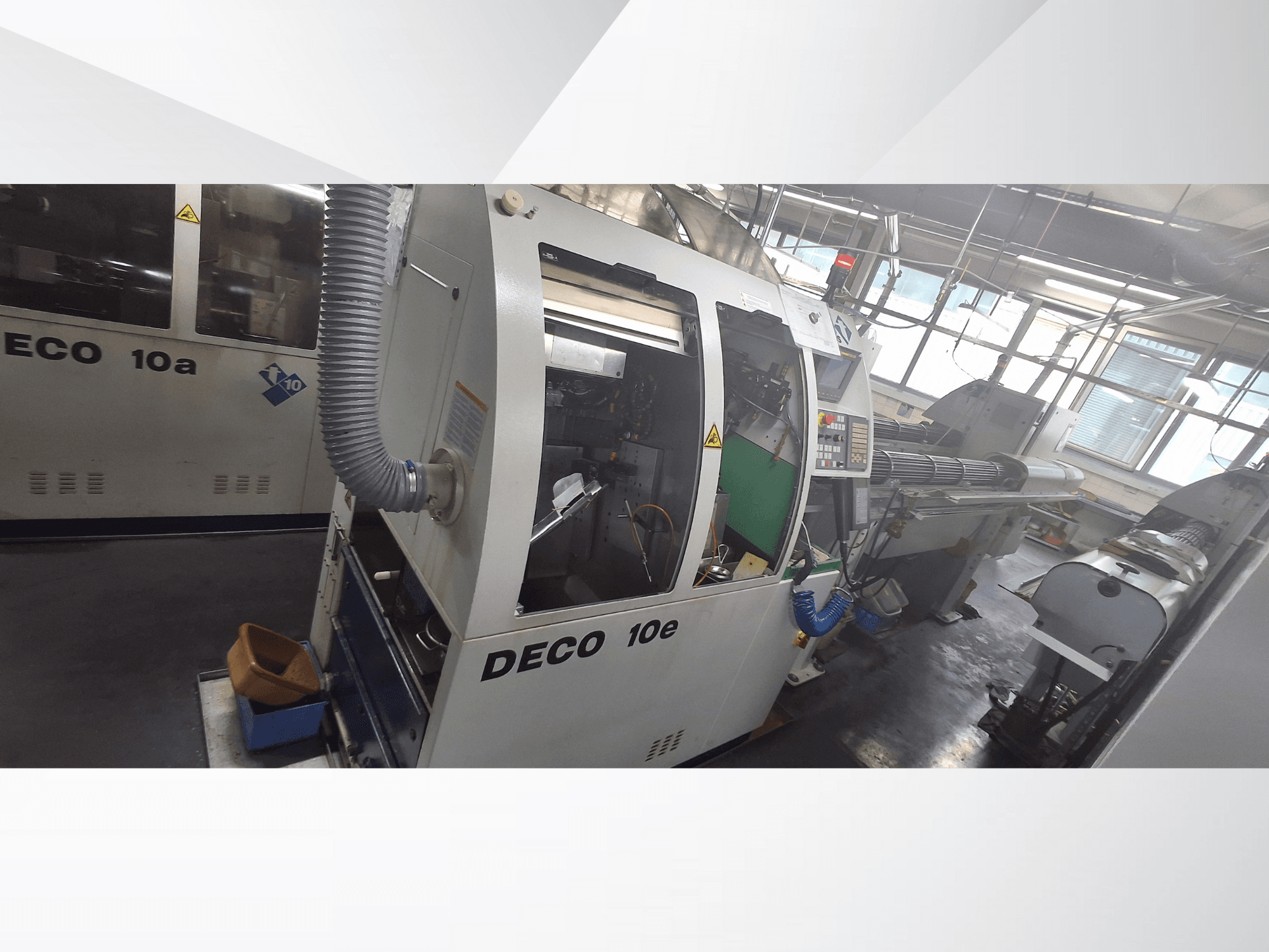 Maszyna CNC DECO 10e w widoku z boku, z panelem sterowania, zielonym wnętrzem i podłączonym wężem wydechowym.