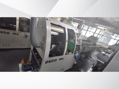 Maszyna CNC DECO 10e w widoku z boku, z panelem sterowania, zielonym wnętrzem i podłączonym wężem wydechowym.