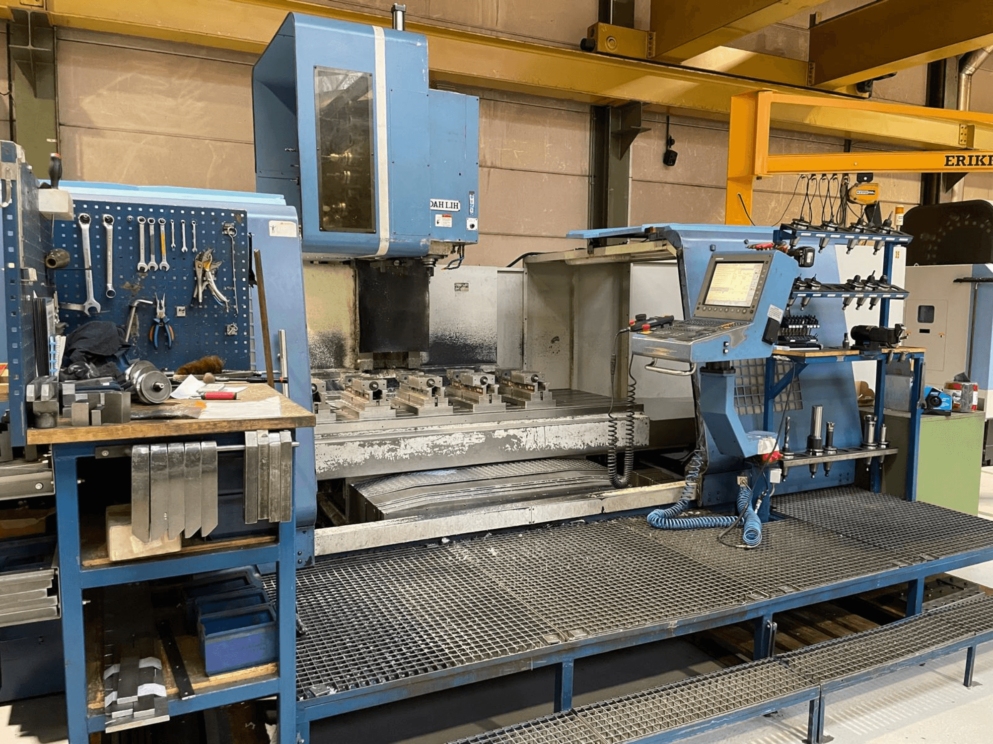 Widok z przodu pionowego centrum obróbczego DAH LIH MCV2600, przedstawiający panel sterowania, stół roboczy i obszar przechowywania narzędzi.