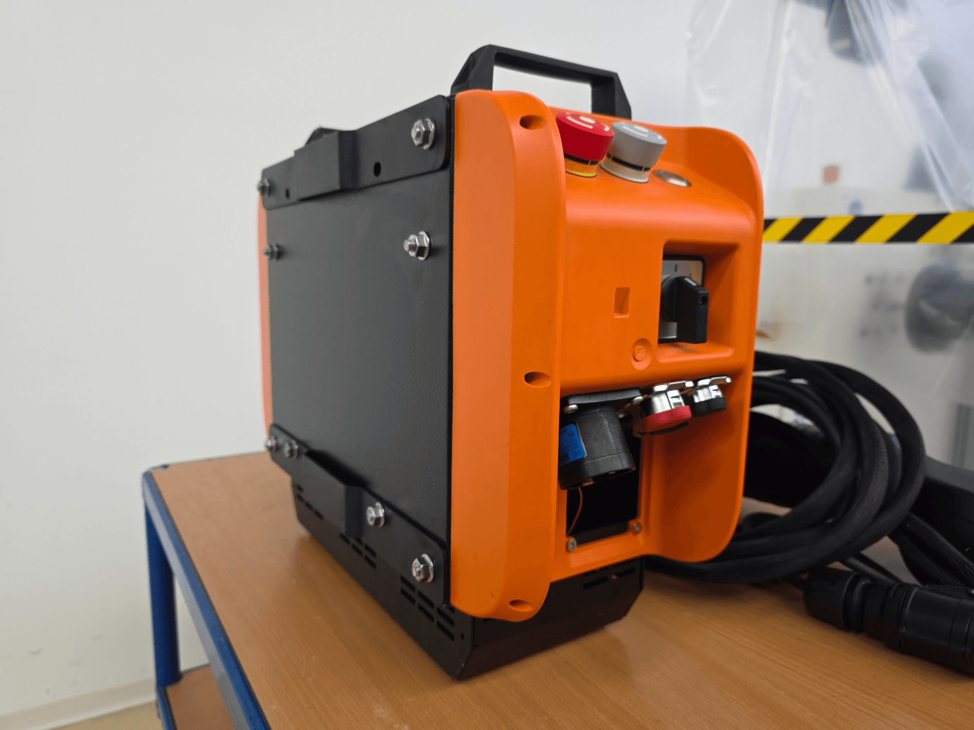 Kontroler ramienia robota KASSOW ROBOTS KR1205, widok z boku przedstawiający pomarańczowo-czarną konstrukcję, porty wejścia/wyjścia i kable.
