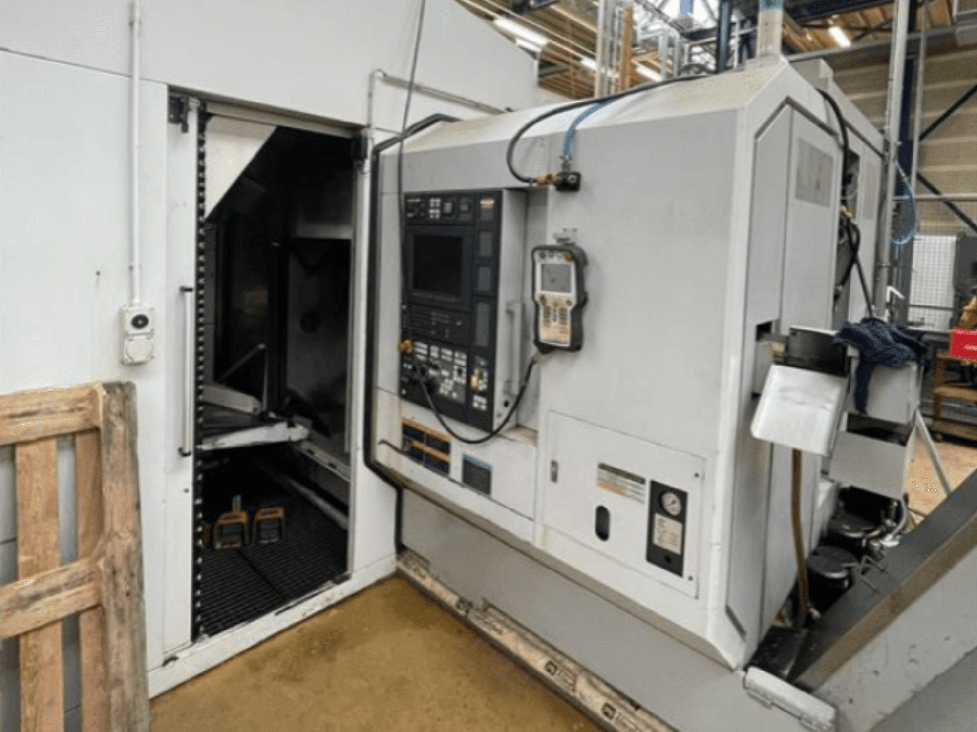 Tokarka pozioma DMG Mori Seiki NZ2000T3Y2, widok z boku przedstawiający panel sterowania i wnętrze maszyny.