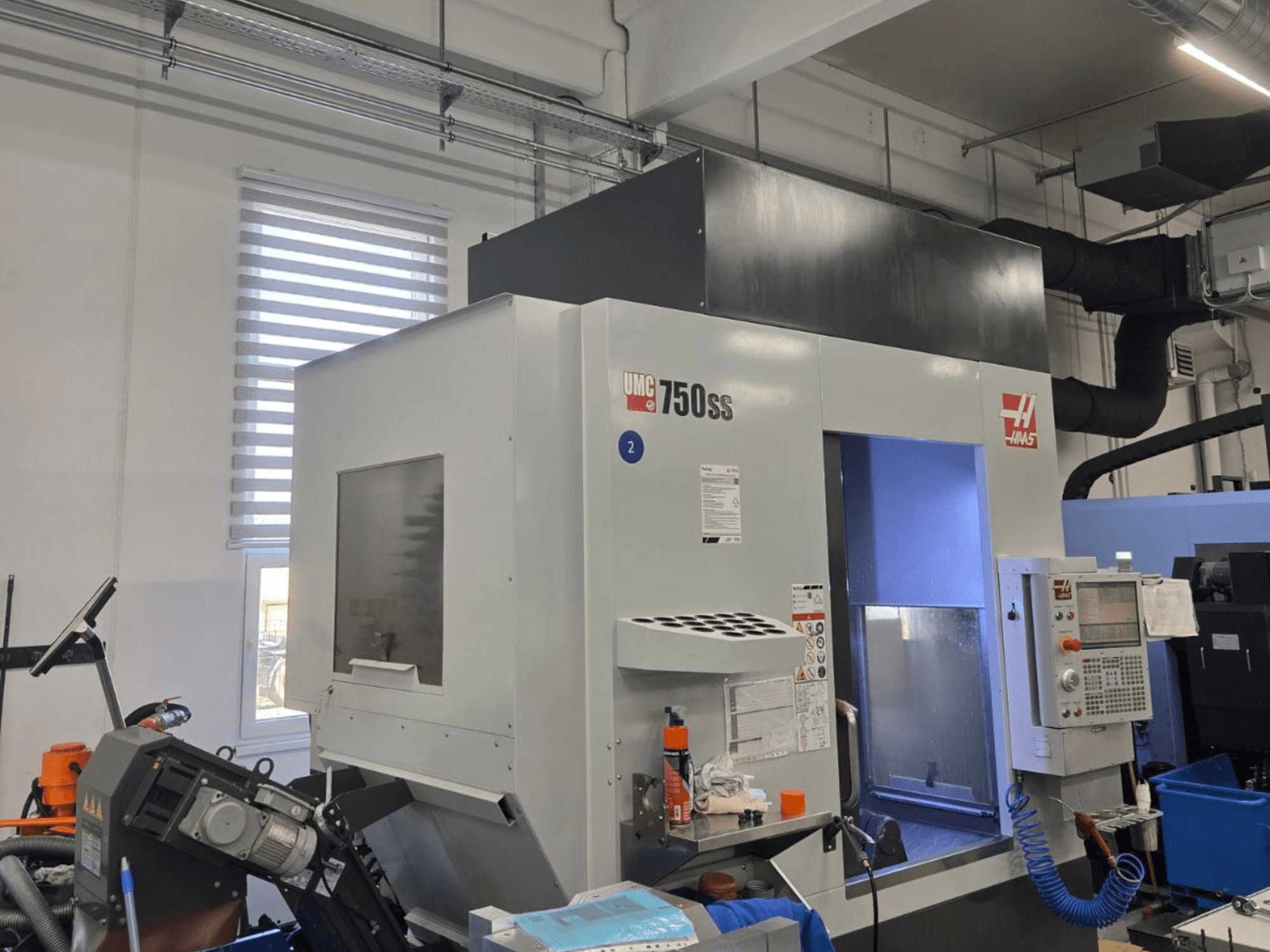 Pionowe centrum obróbcze Haas UMC-750SS, widok z przodu, z panelem sterowania i wyraźnym dostępem do obszaru obróbki.
