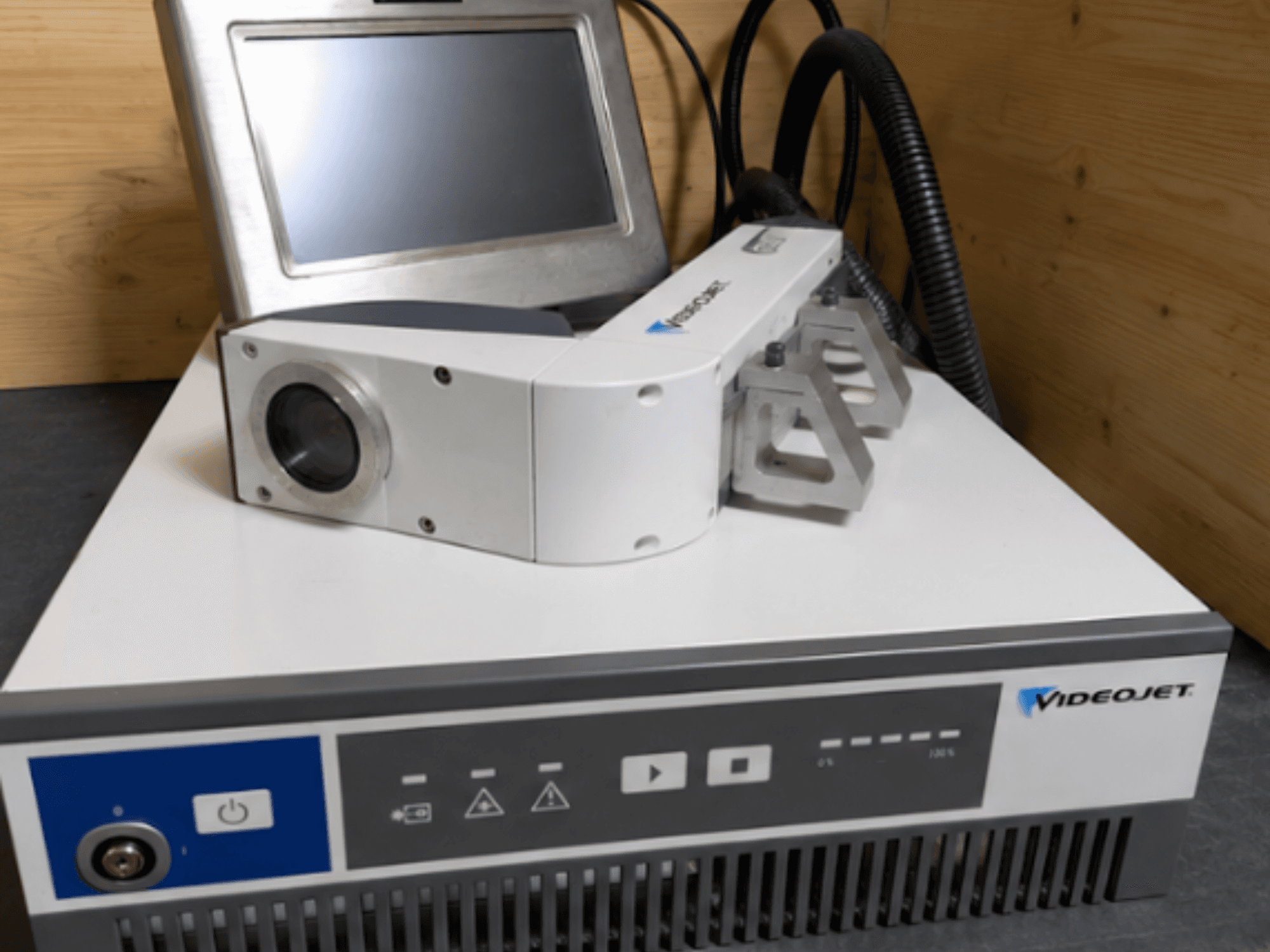 Grawerka laserowa Videojet 7230, widok z przodu, pokazujący panel sterowania i głowicę laserową z soczewką i mocowaniem.
