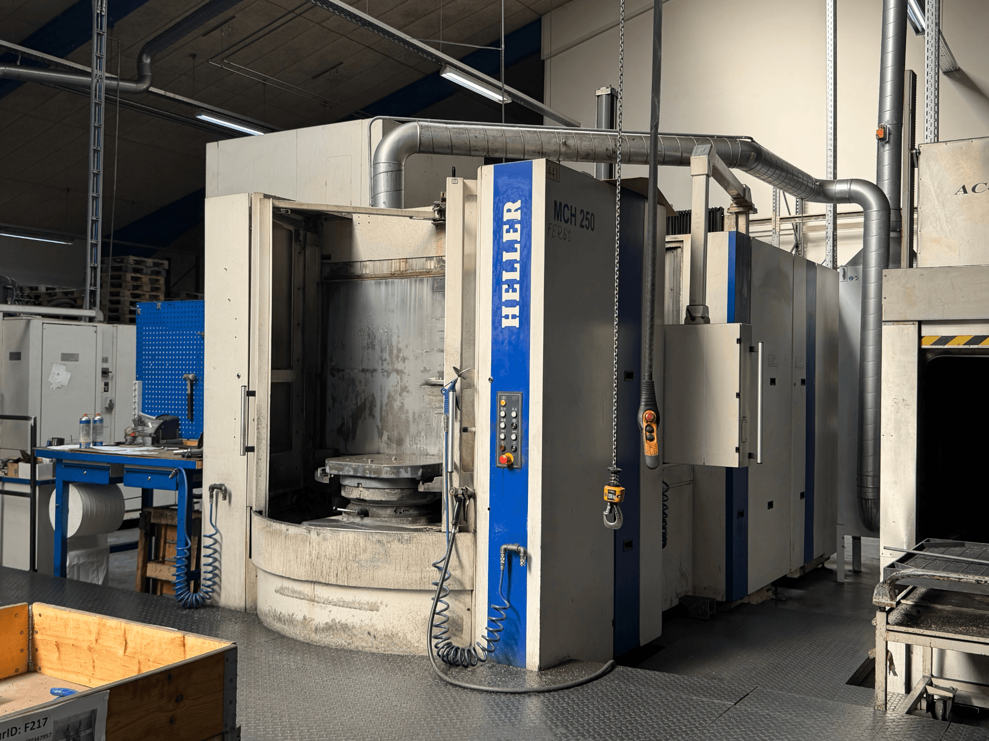 Widok z przodu poziomego centrum obróbczego HELLER MCH 250 z panelem sterowania, dużym stołem obrotowym i środowiskiem przemysłowym.