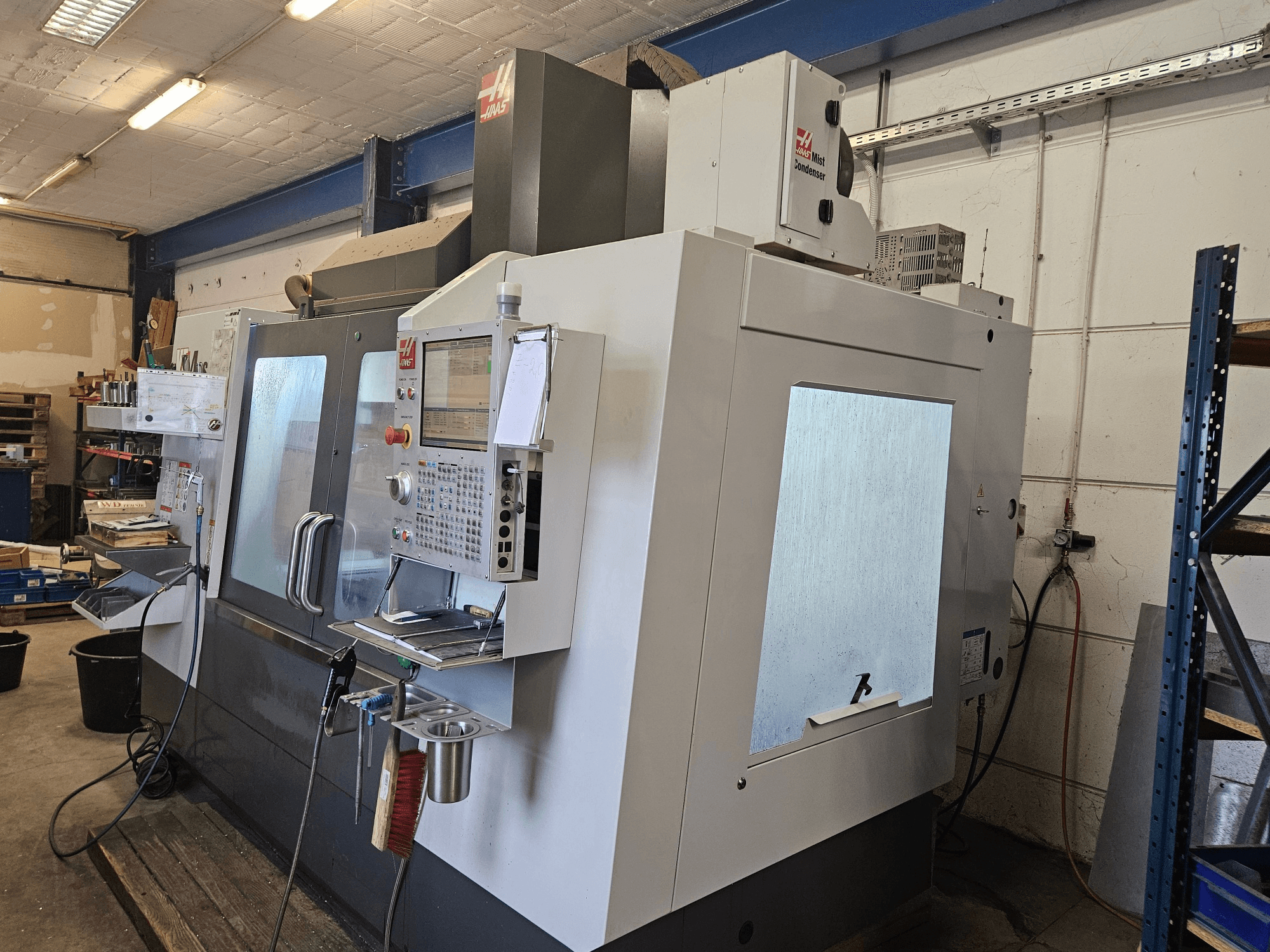 Pionowe centrum obróbcze HAAS VF-4SS widziane z przodu, wyposażone w panel sterowania i duże okna obserwacyjne.