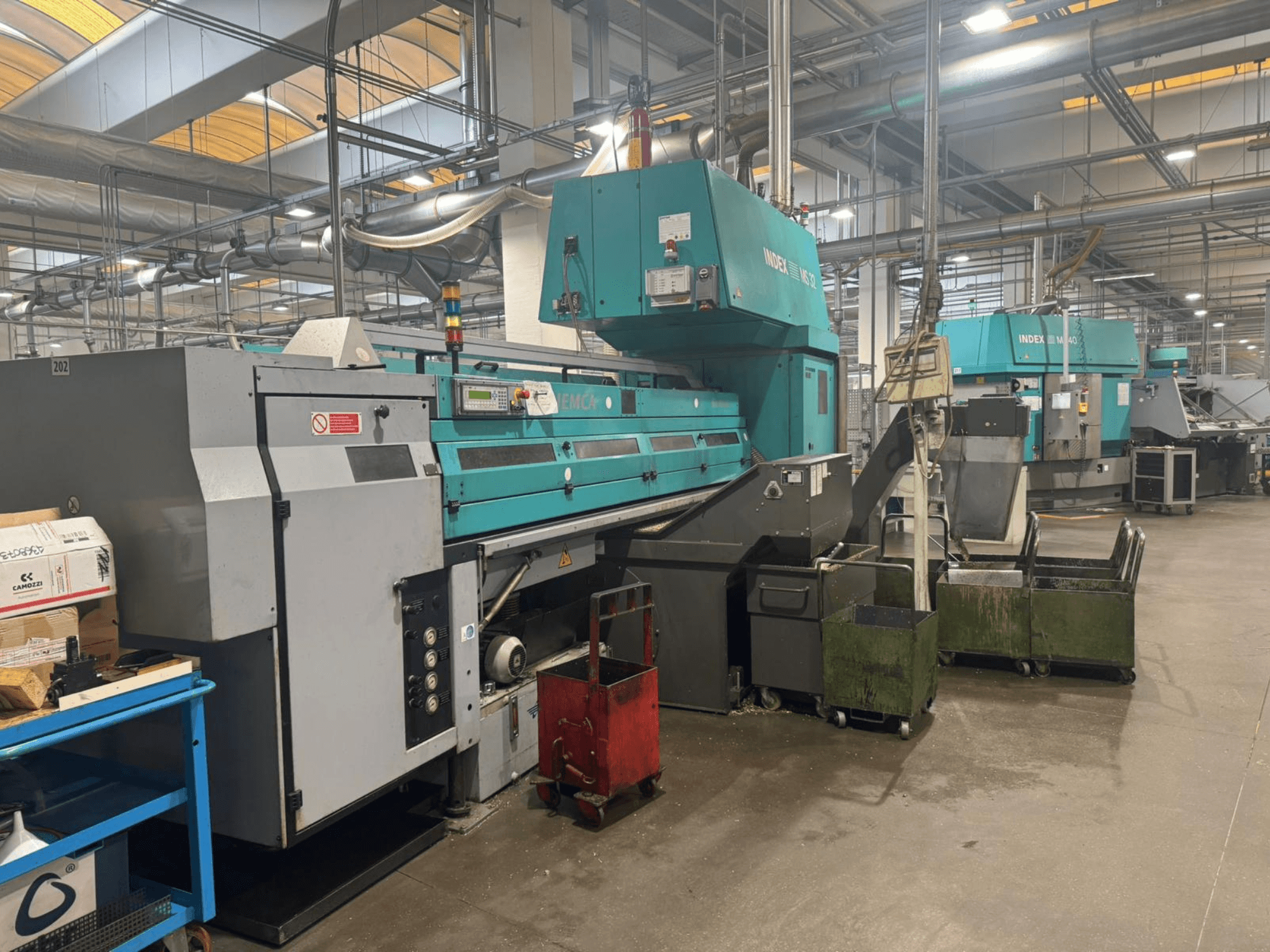 Tokarka wielowrzecionowa INDEX MS32C, widok z przodu przedstawiający elementy sterujące i obszar roboczy w warunkach warsztatowych.