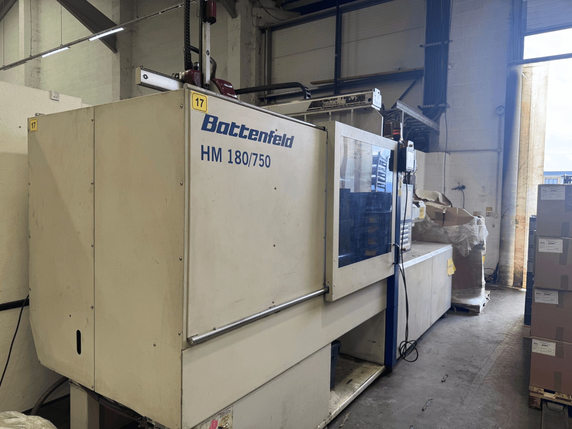Hydrauliczna wtryskarka Battenfeld HM150750 widziana od przodu, prezentująca panel sterowania i otaczające ją ustawienia.