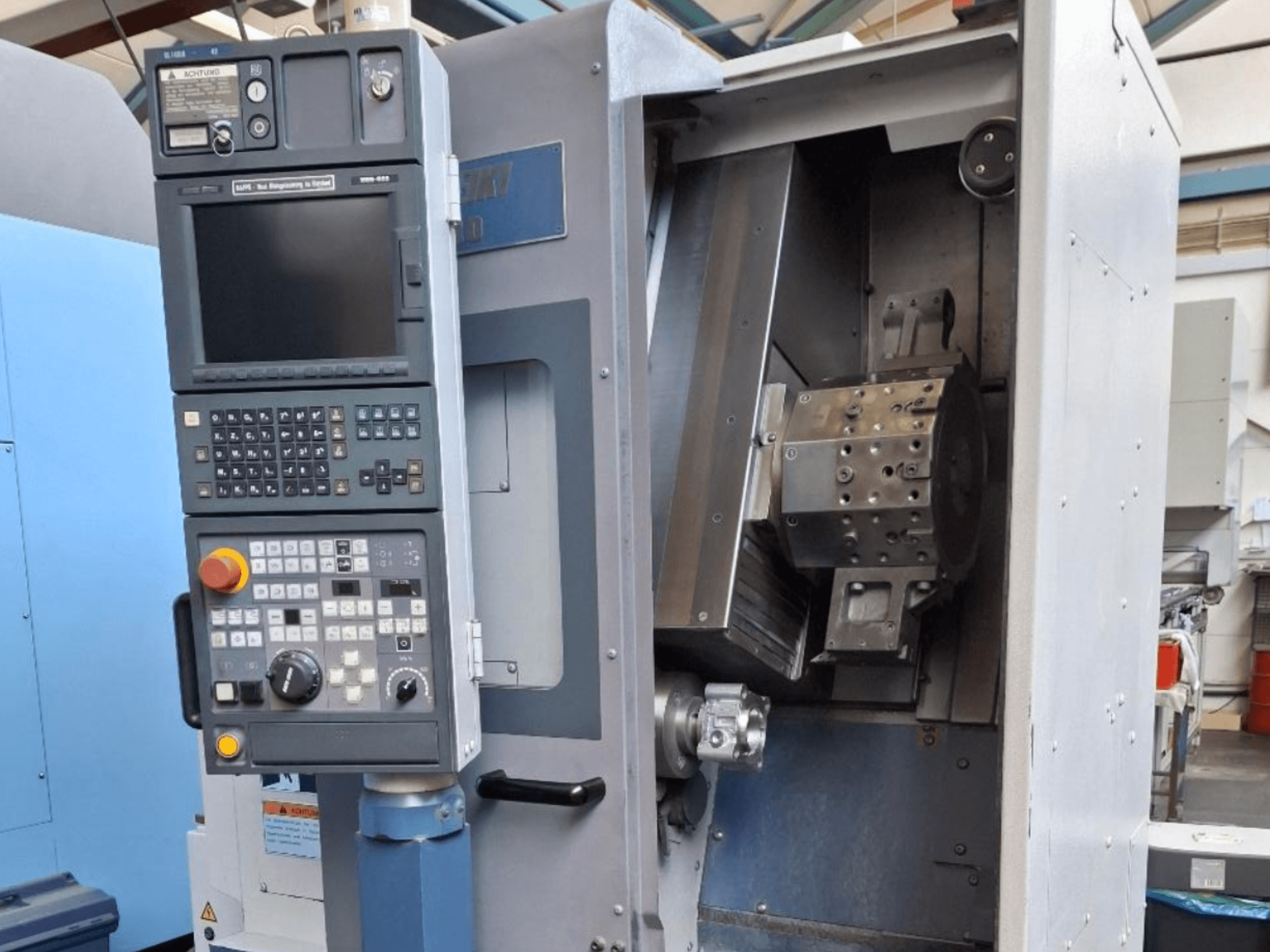 Tokarka pozioma MORI SEIKI SL 1000 widok z przodu, z panelem sterowania i szczegółowym mechanizmem wewnętrznym.