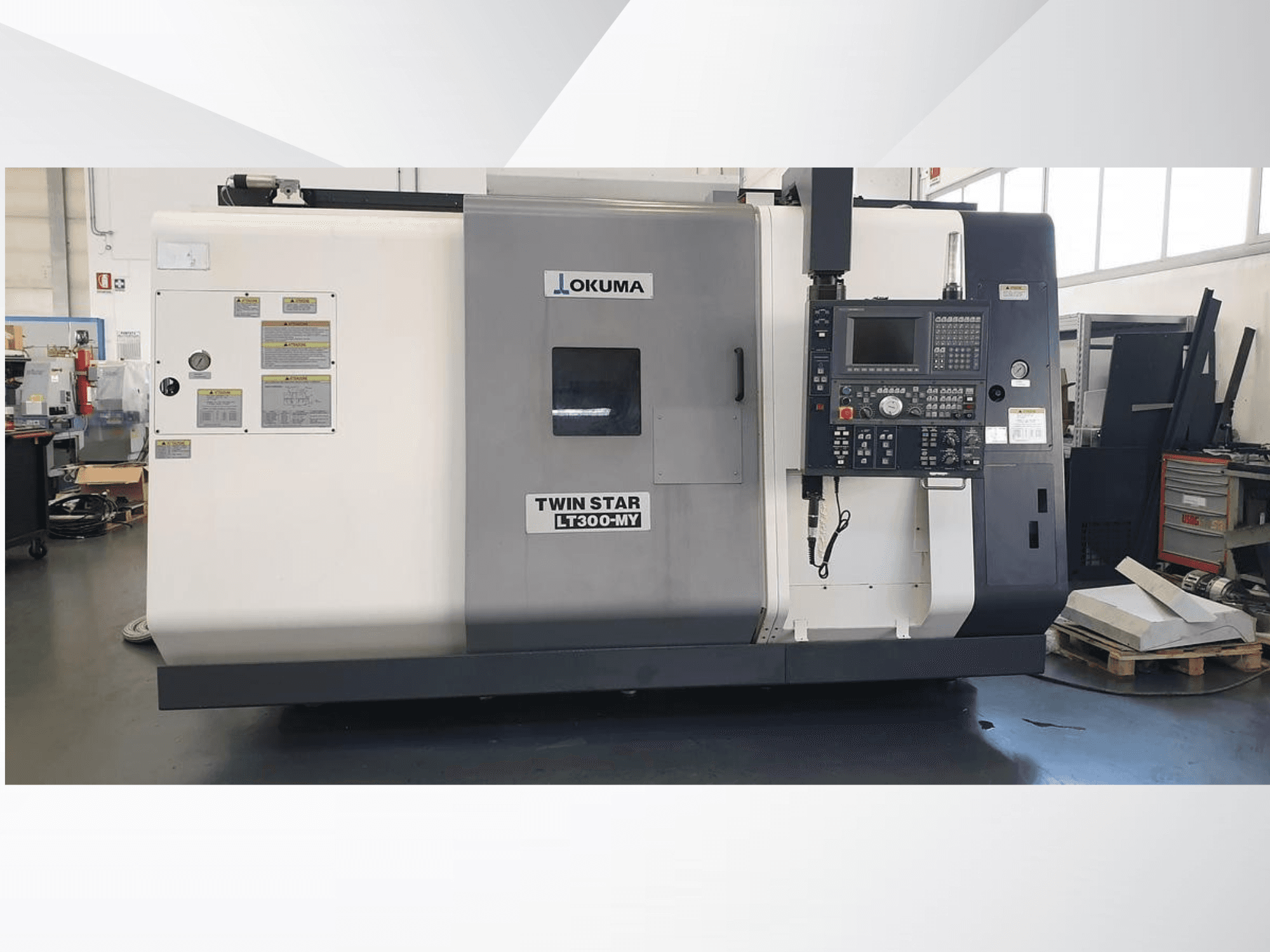 Tokarka CNC Okuma Twin Star LT300-MY, widok z przodu z widocznym panelem sterowania i etykietami operacyjnymi.