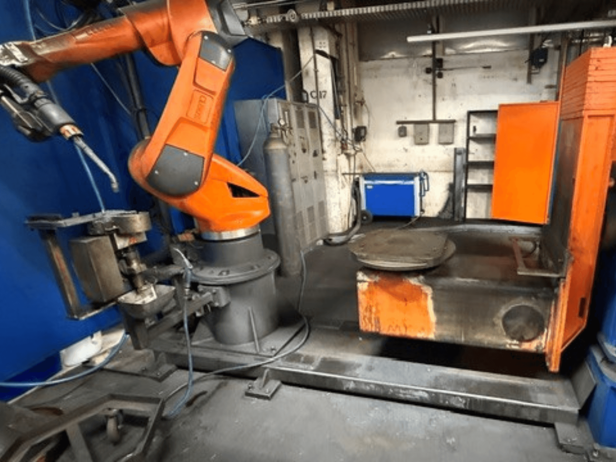 Robot spawalniczy CLOOS C50 widziany z przodu, wyposażony w pomarańczowe ramię robota i metalowy stół roboczy.