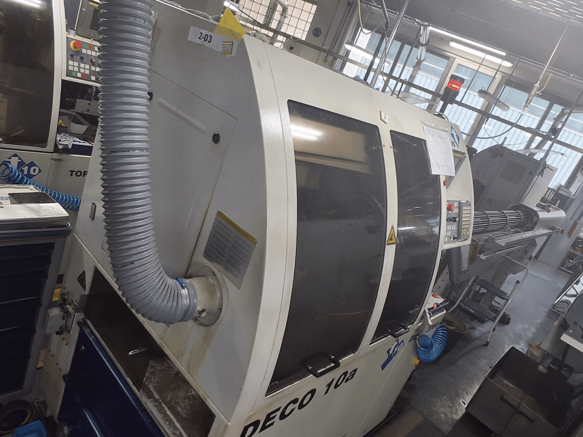 Maszyna DECO 10a w widoku z przodu; widoczny duży panel sterowania, kanały i naklejki operacyjne.