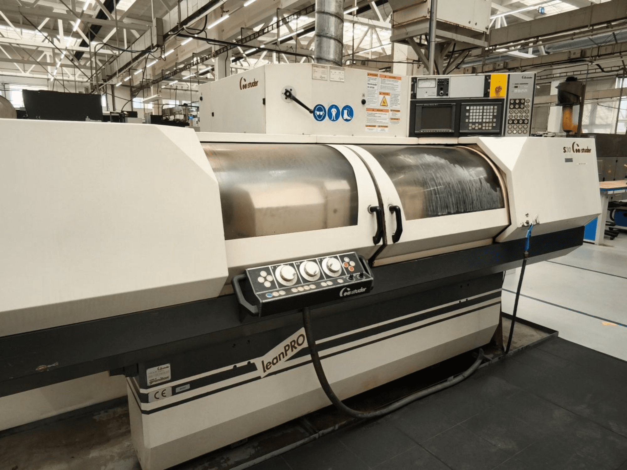 Szlifierka cylindryczna STUDER S30 LEAN PRO, widok z boku, panel sterowania i osłona ściernicy w warunkach przemysłowych.