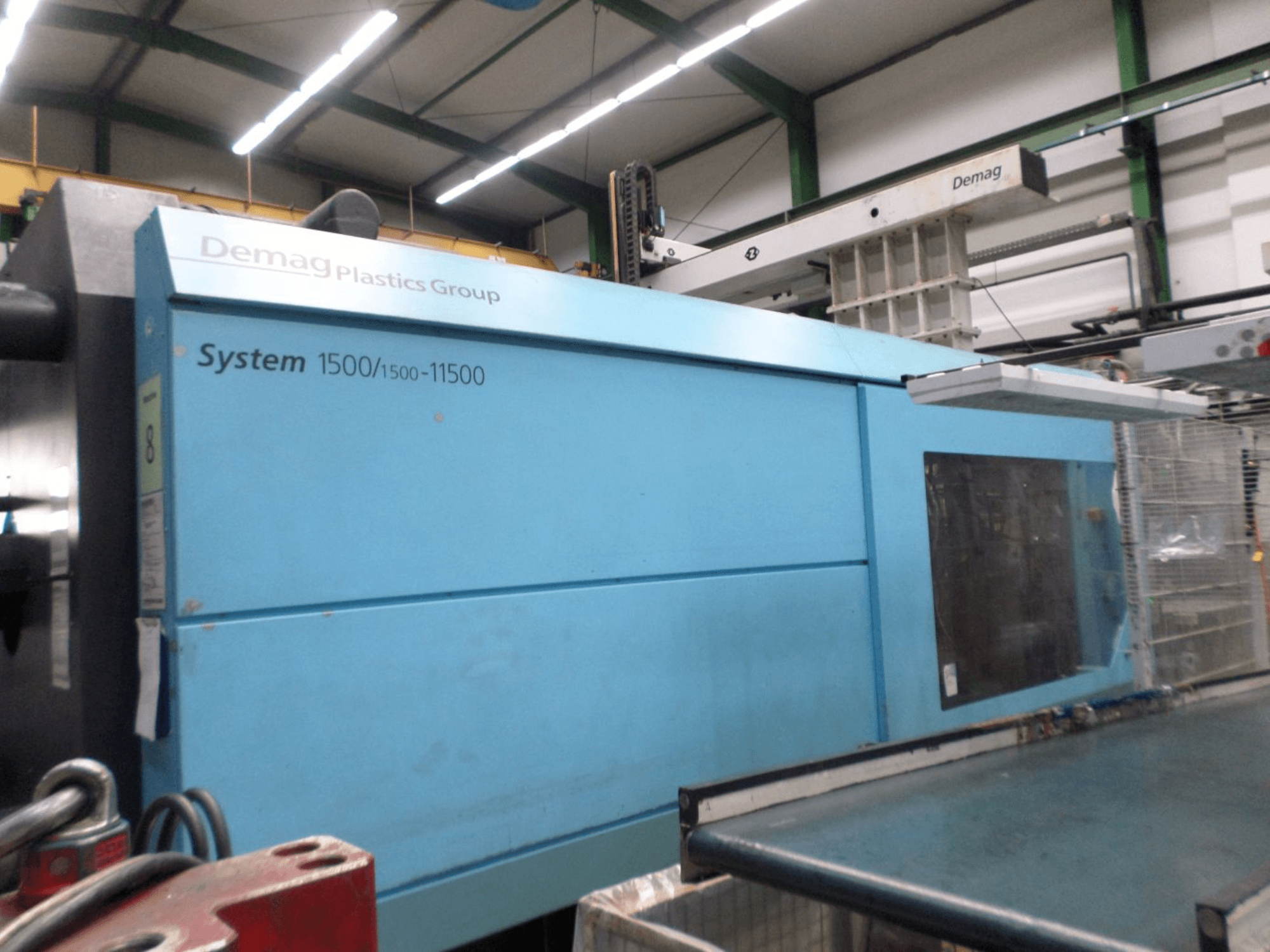 Hydrauliczna wtryskarka Demag D 650 w kolorze niebieskim – widok z boku przedstawiający etykietę „System 1500/1500-11500” oraz obszar obsługi.