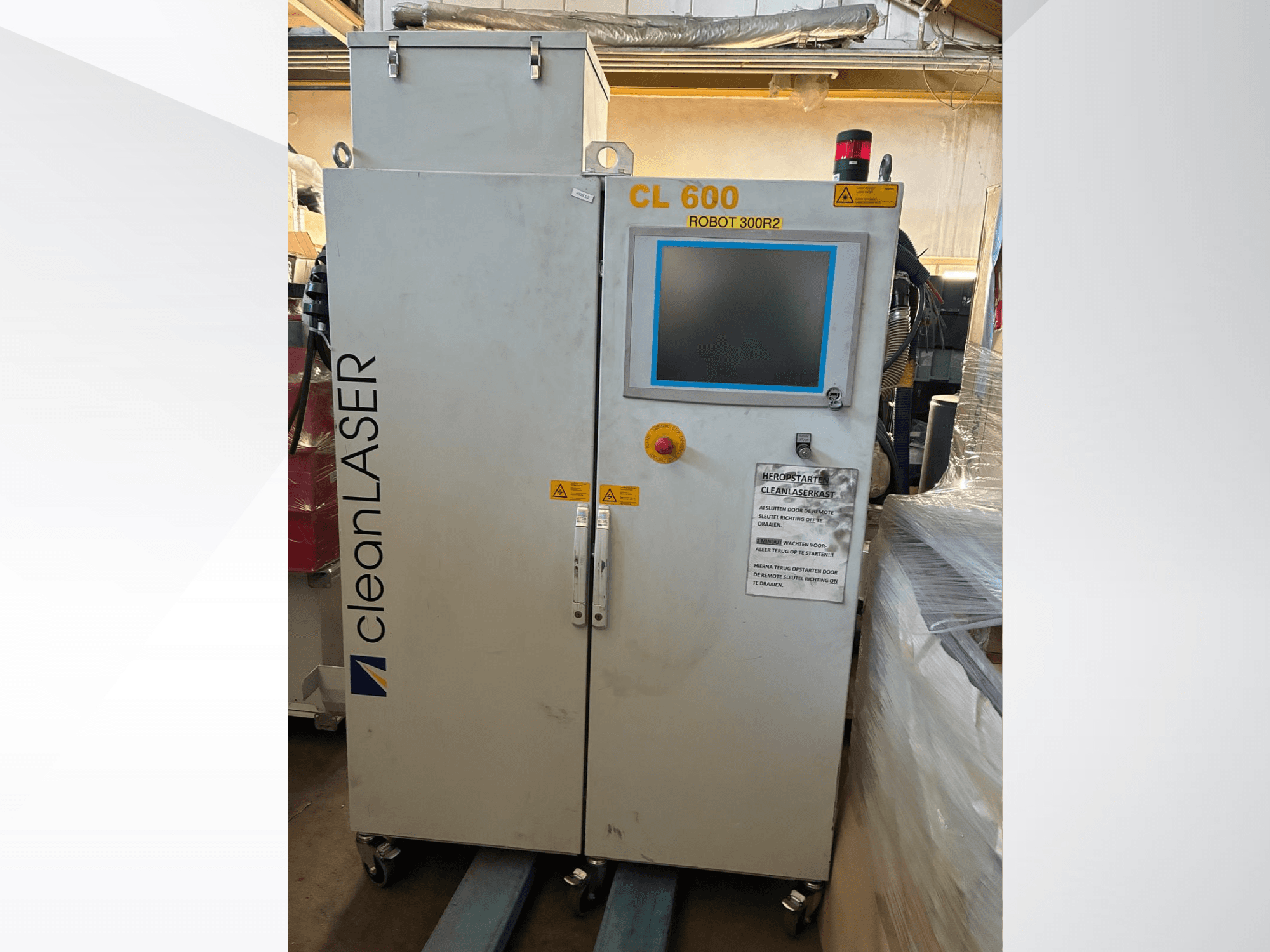 System automatyzacji CLEAN LASER CL 600 – widok z przodu z wyświetlaczem LCD, etykietami ostrzegawczymi i przyciskami sterującymi na drzwiach.