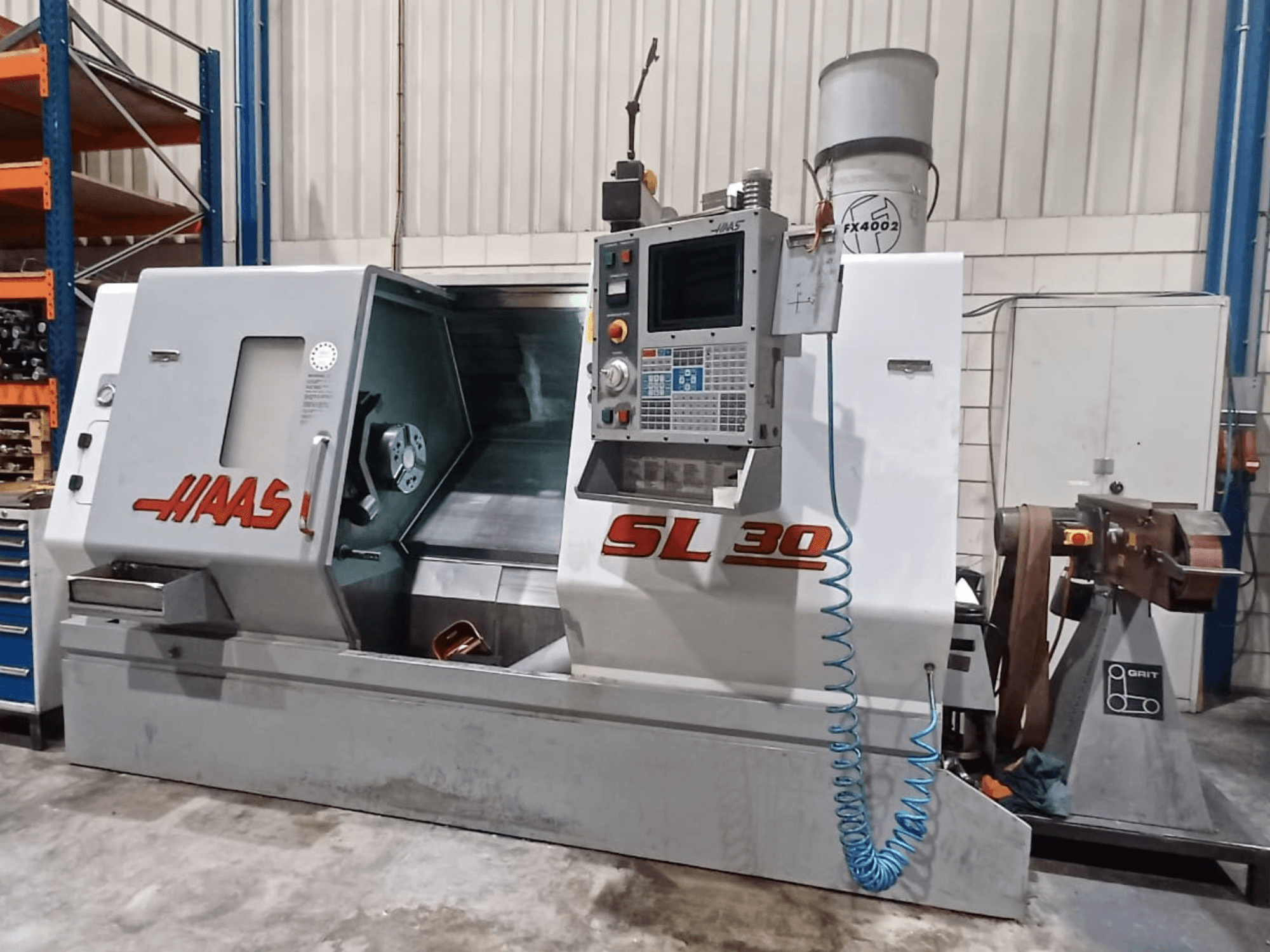 Tokarka CNC Haas SL 30 w widoku z boku, z panelem sterowania, obszarem obróbki i zintegrowanym systemem chłodzenia do obróbki metalu.