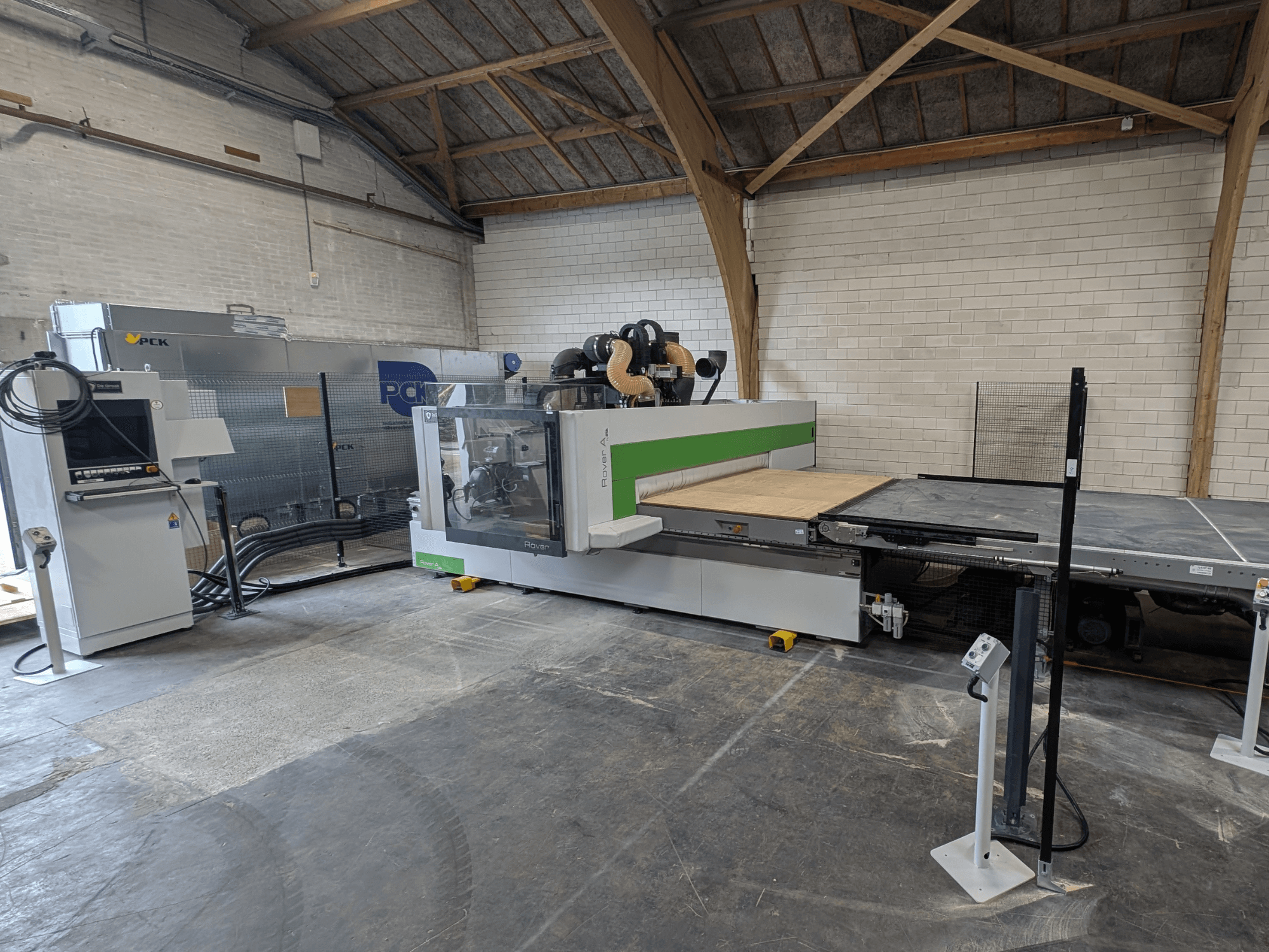 Centrum obróbcze CNC PCK, widok z przodu, posiada duże łoże tnące, panel sterowania, system odsysania pyłu i solidną konstrukcję.