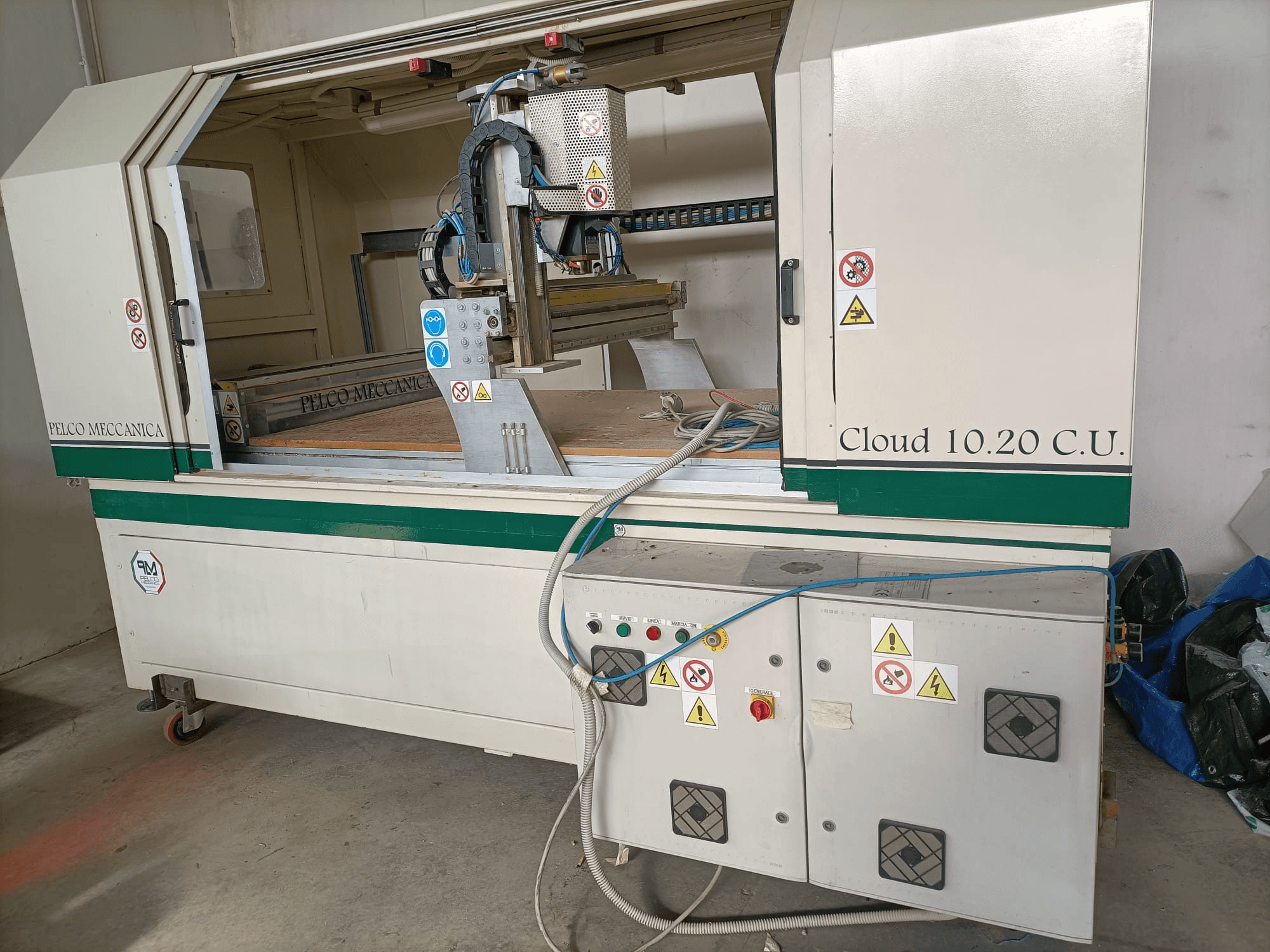 Frezarka CNC MECCANICA CLOUD 10.20 C.U., widok z przodu przedstawiający panel sterowania i obszar roboczy, widoczne etykiety bezpieczeństwa i węże.