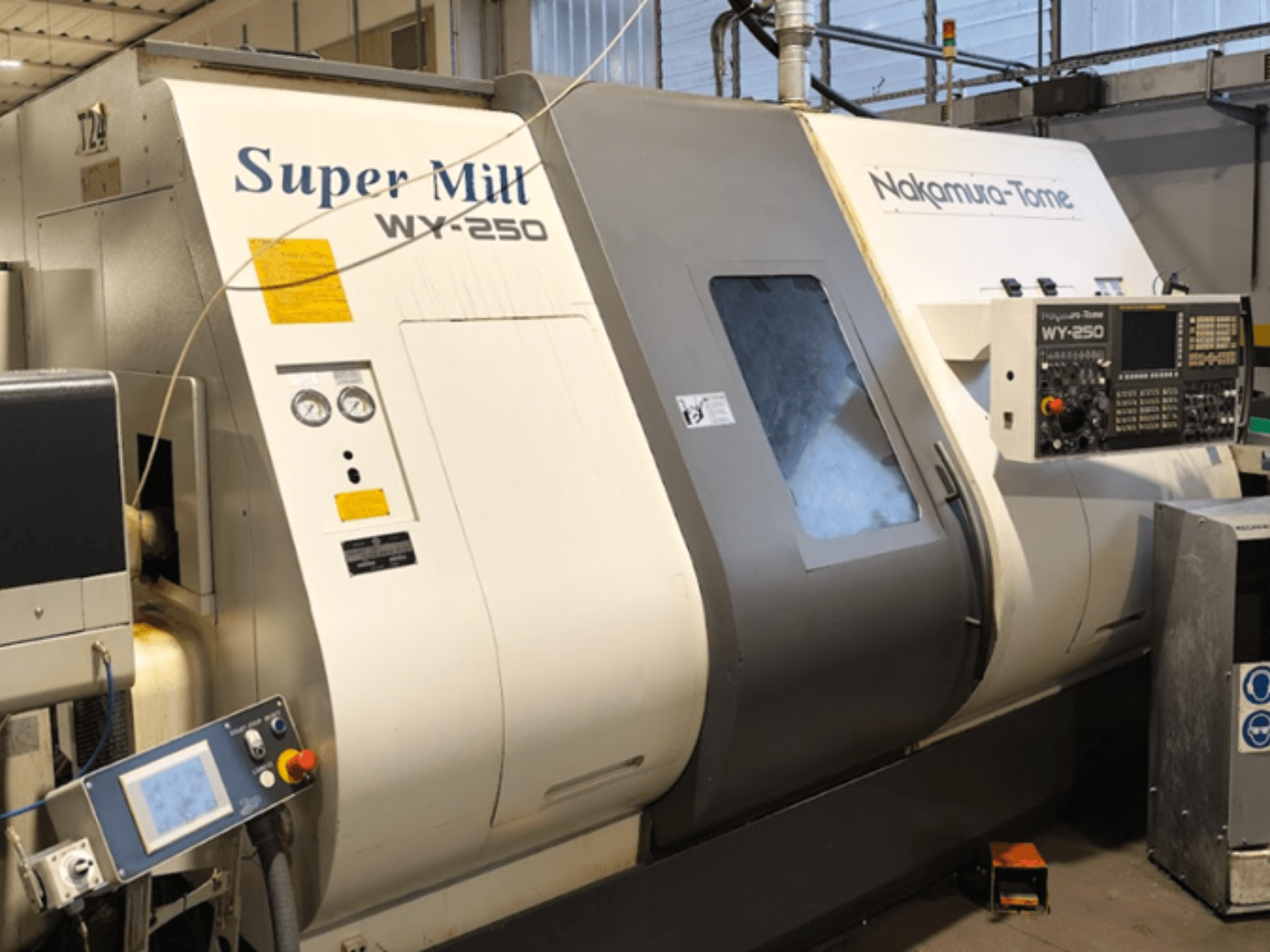 Tokarka pozioma NAKAMURA-TOME WY 250 w widoku z przodu; posiada panel sterowania i wyświetlacz z napisem "Super Mill".