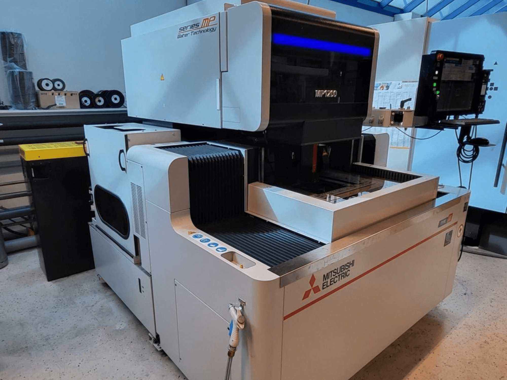 Maszyna do elektroerozji drutowej Mitsubishi MP1200, widok z przodu, z panelem sterowania, zaawansowanymi technologicznie elementami i eleganckim wyglądem.