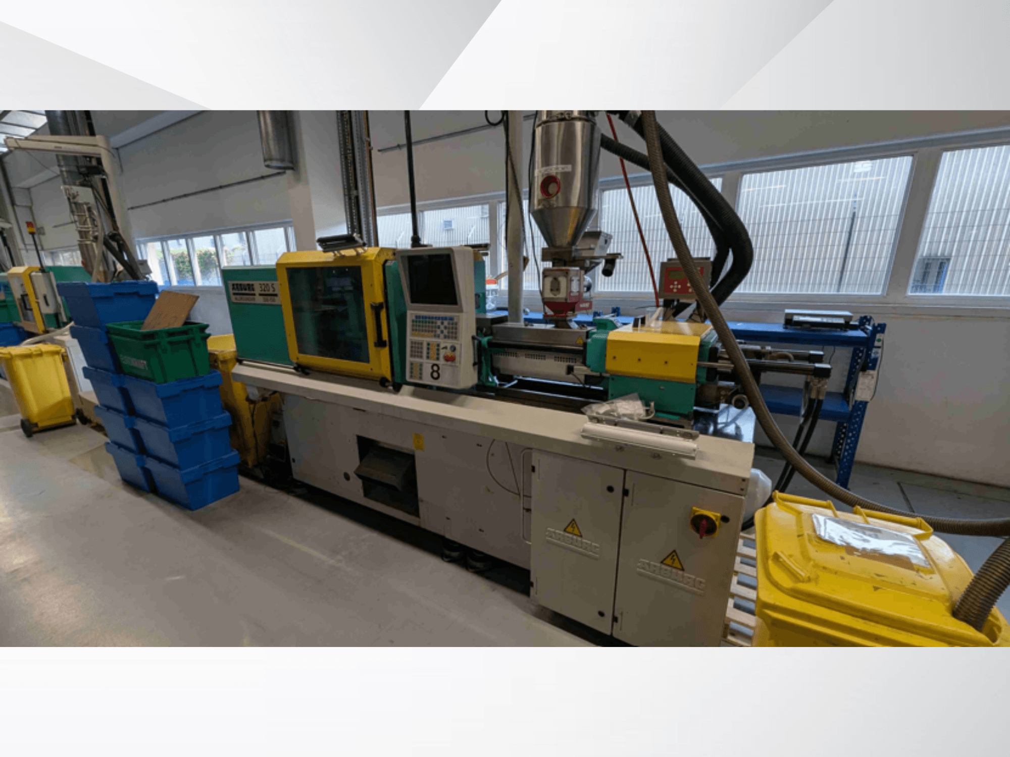 Hydrauliczna wtryskarka Arburg 320 S 350-150, widok z przodu, przedstawiająca elementy sterujące, ekstruder i pojemniki na kolorowe tworzywa.
