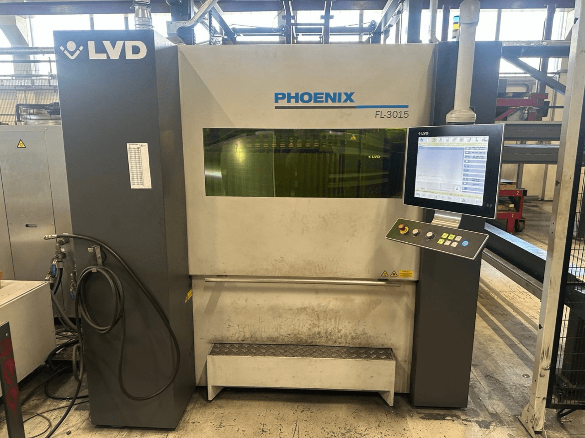 Wycinarka laserowa LVD Phoenix FL-3015, widok z przodu, posiada cyfrowy panel sterowania i widoczne przewody rurowe.